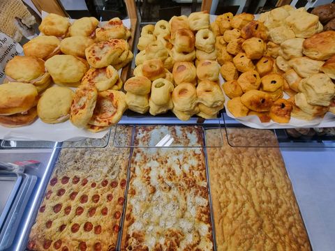 Esposizione di prodotti da forno: panini vari e focacce.