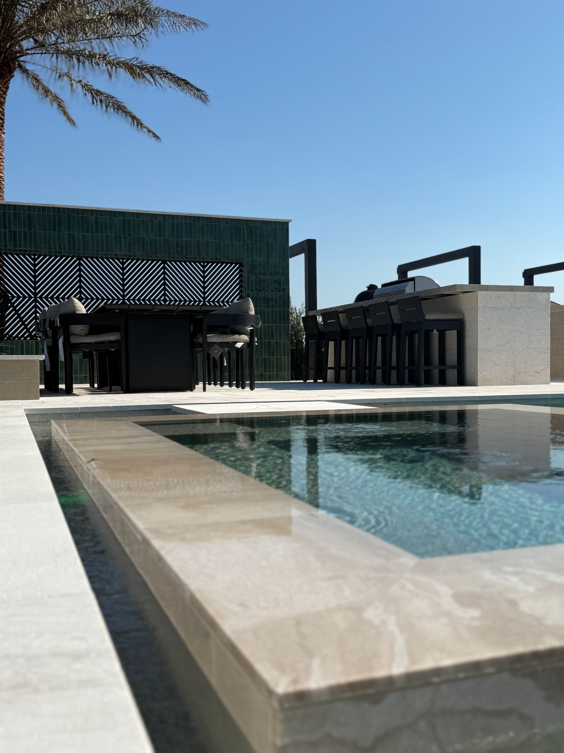 Poolside outdoor bar and dining area on a sunny day.