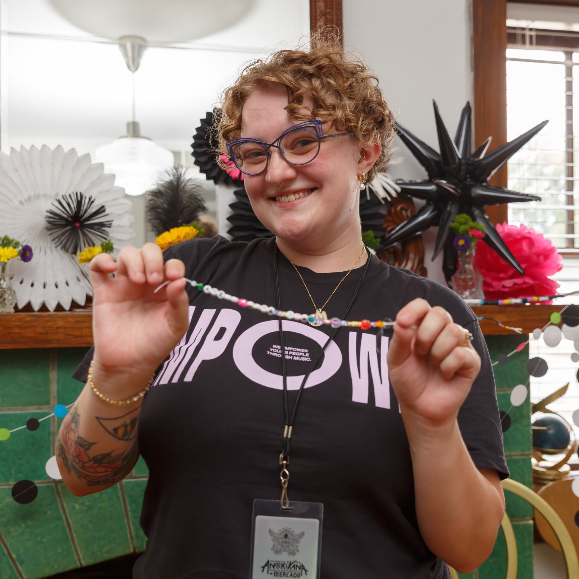 A man in a white shirt and brown pants is holding a tie over his shoulder