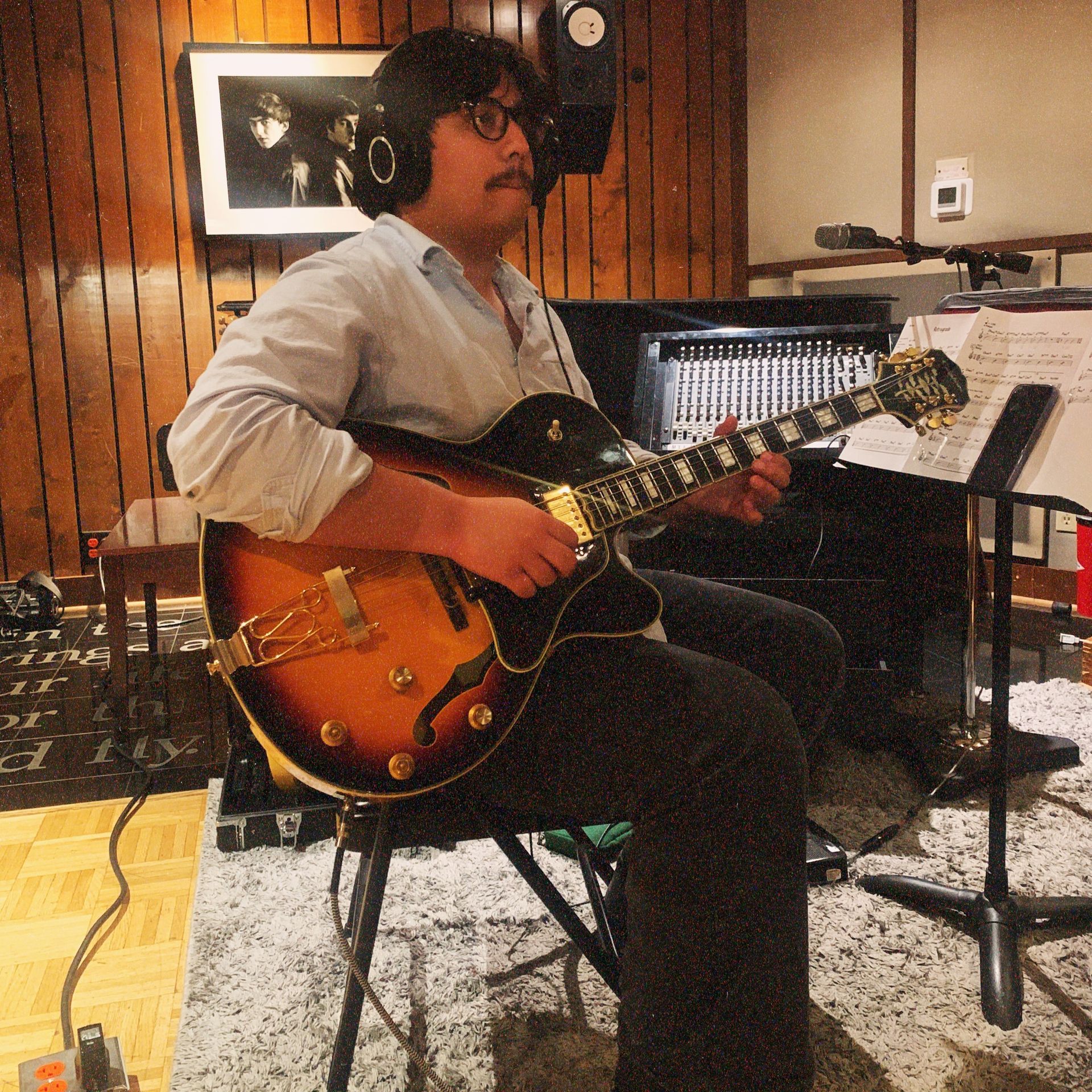 A man in a white shirt and brown pants is holding a tie over his shoulder