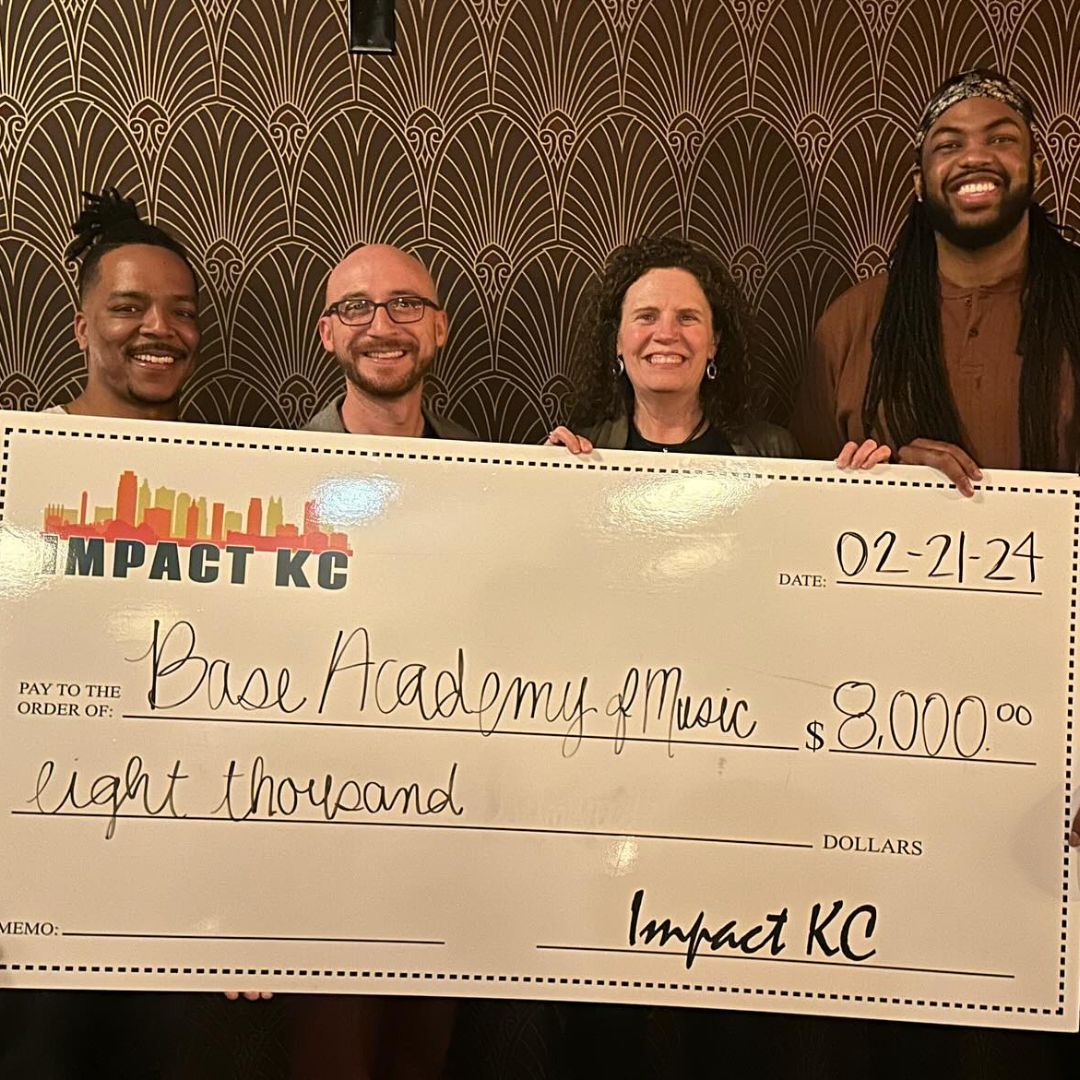A group of people are holding a large check.