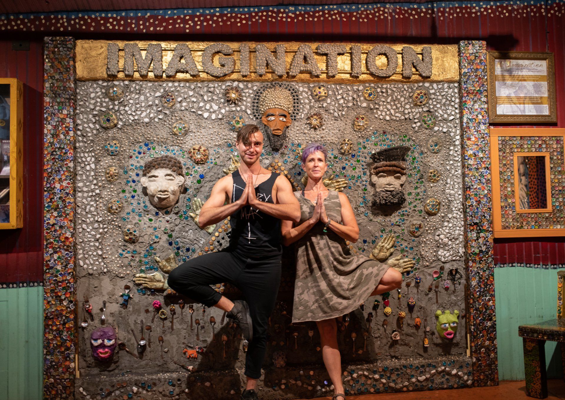 A man and a woman are standing in front of a wall that says imagination