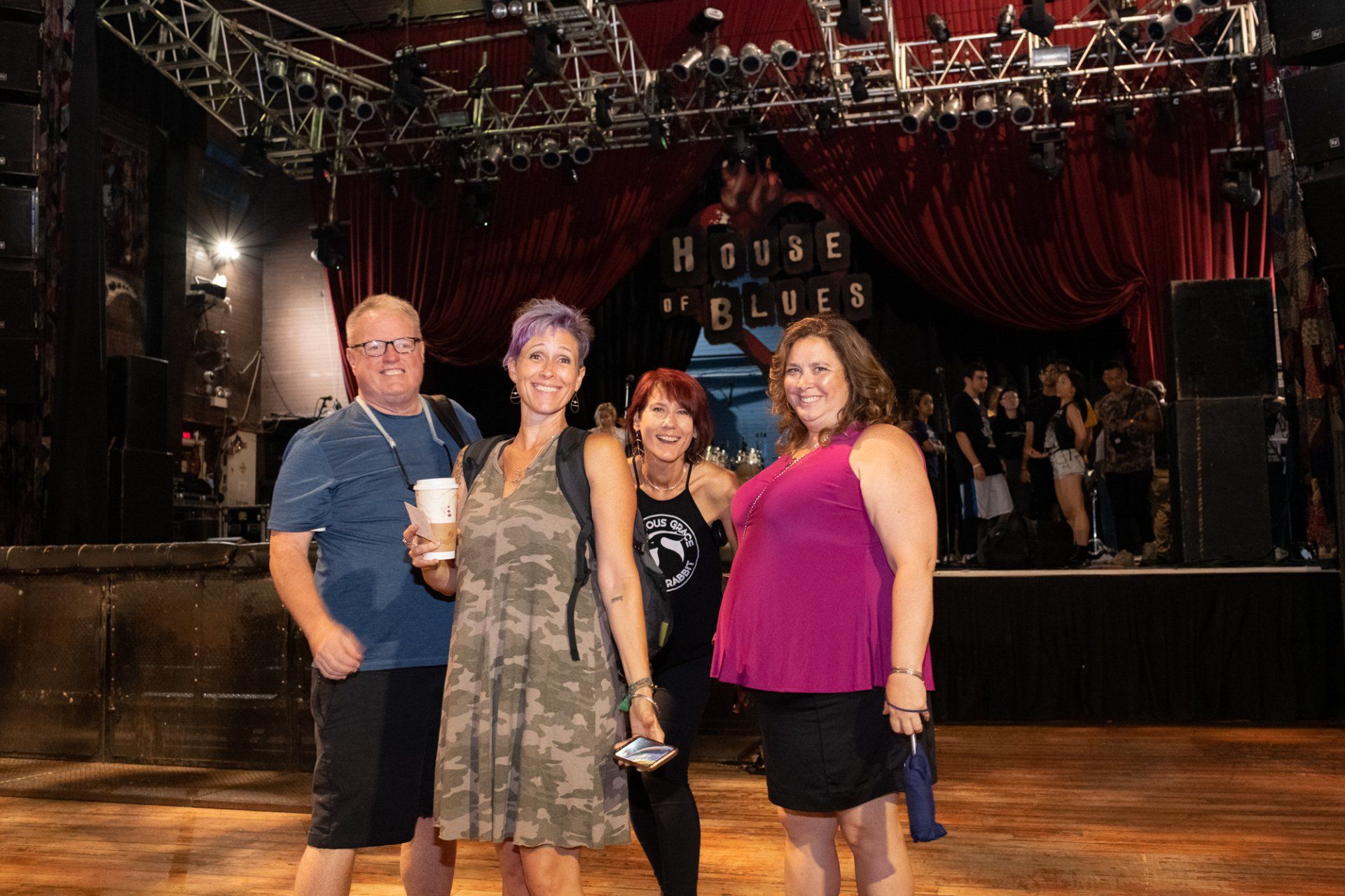 A group of people are posing for a picture in front of a stage.