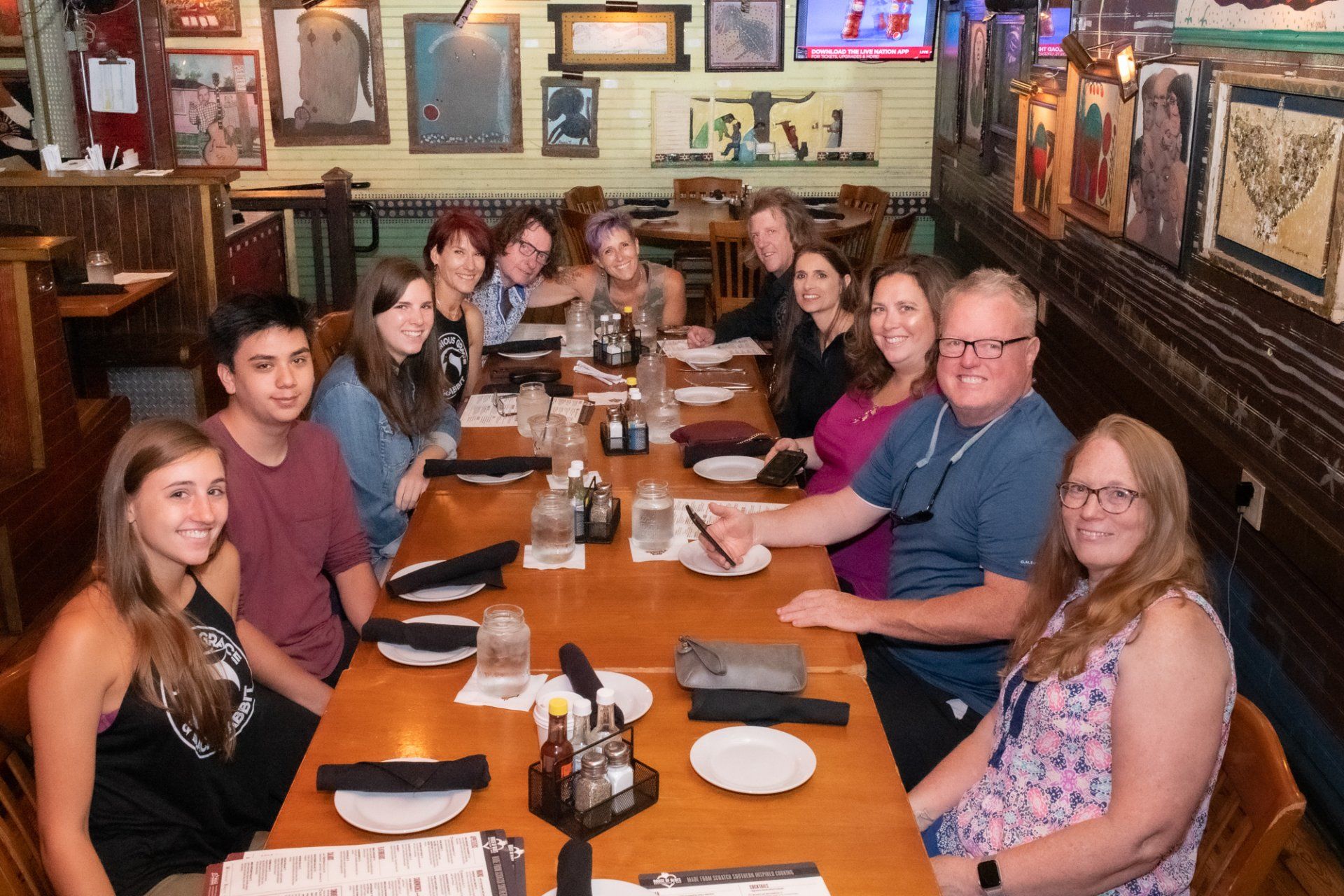A group of people are sitting at a long table in a restaurant.