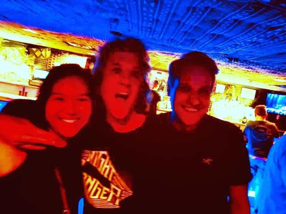 Three people are posing for a picture and one of them is wearing a shirt that says thunder