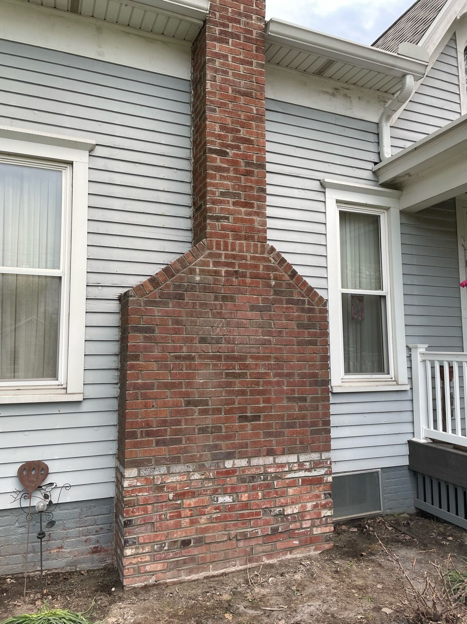 A large brick chimney is on the side of a house.