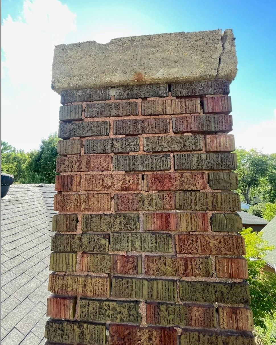 A brick chimney is sitting on top of a roof.