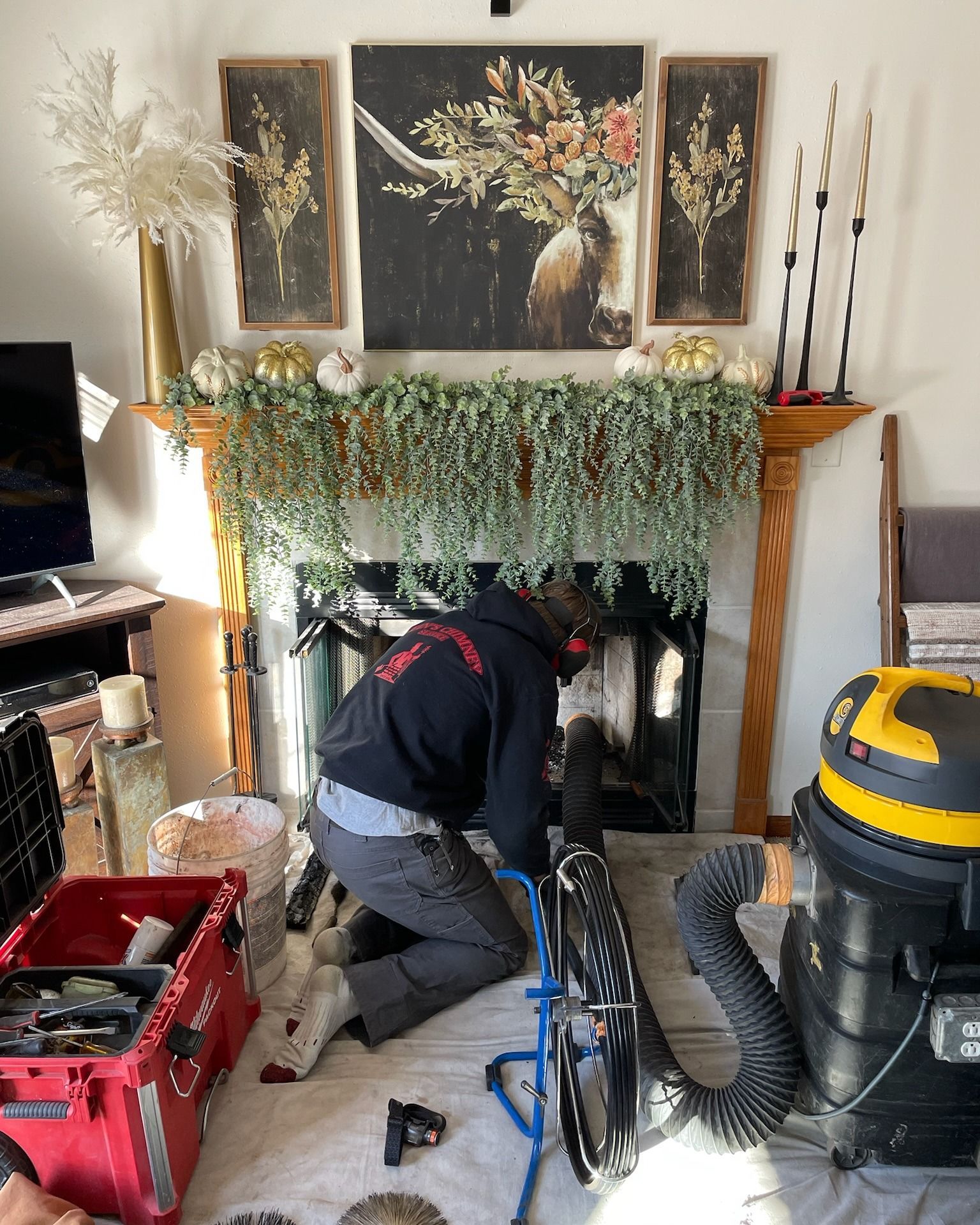 A man is working on a fireplace in a living room.