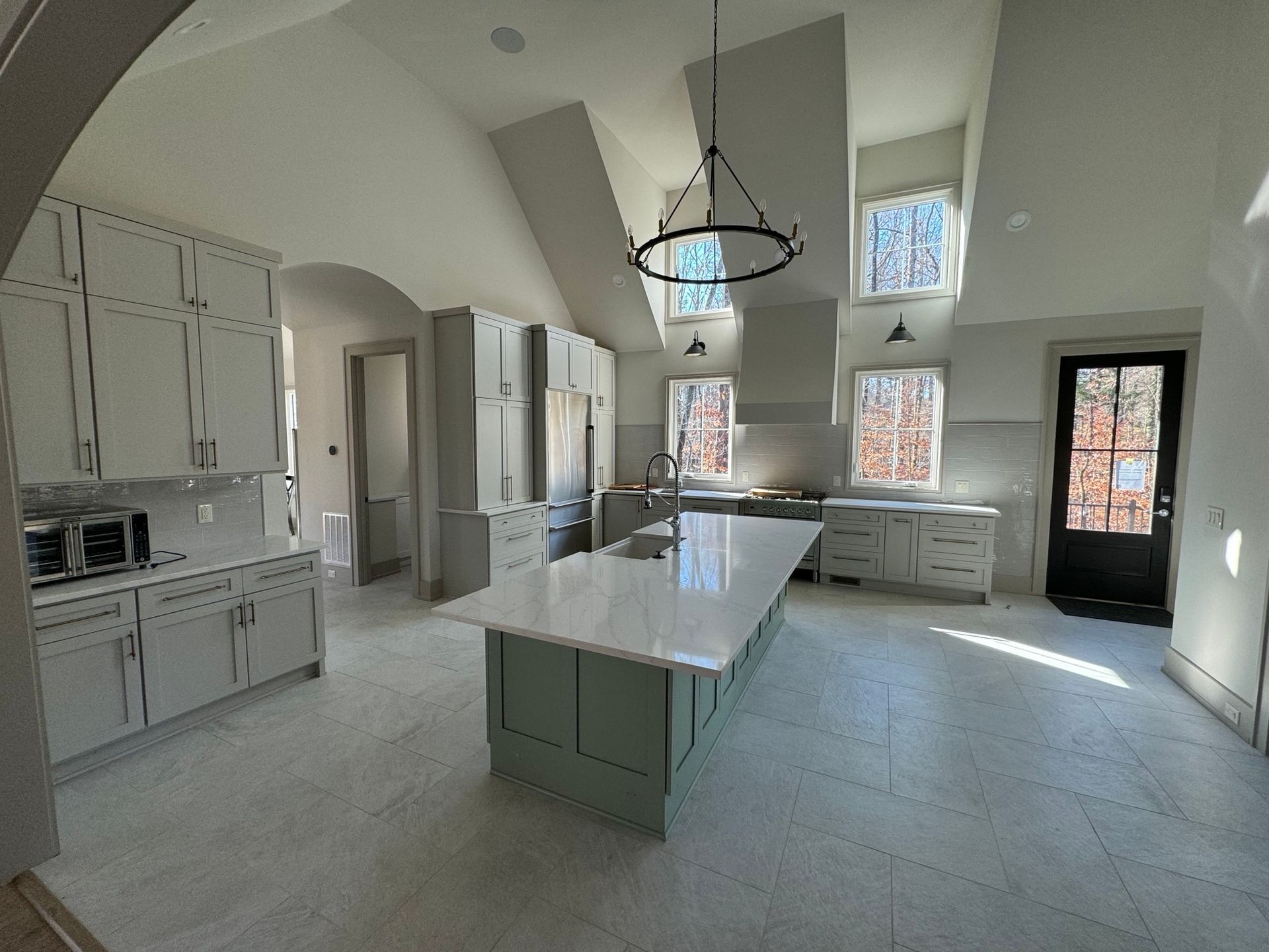 A large kitchen with white cabinets and a large island in the middle.
