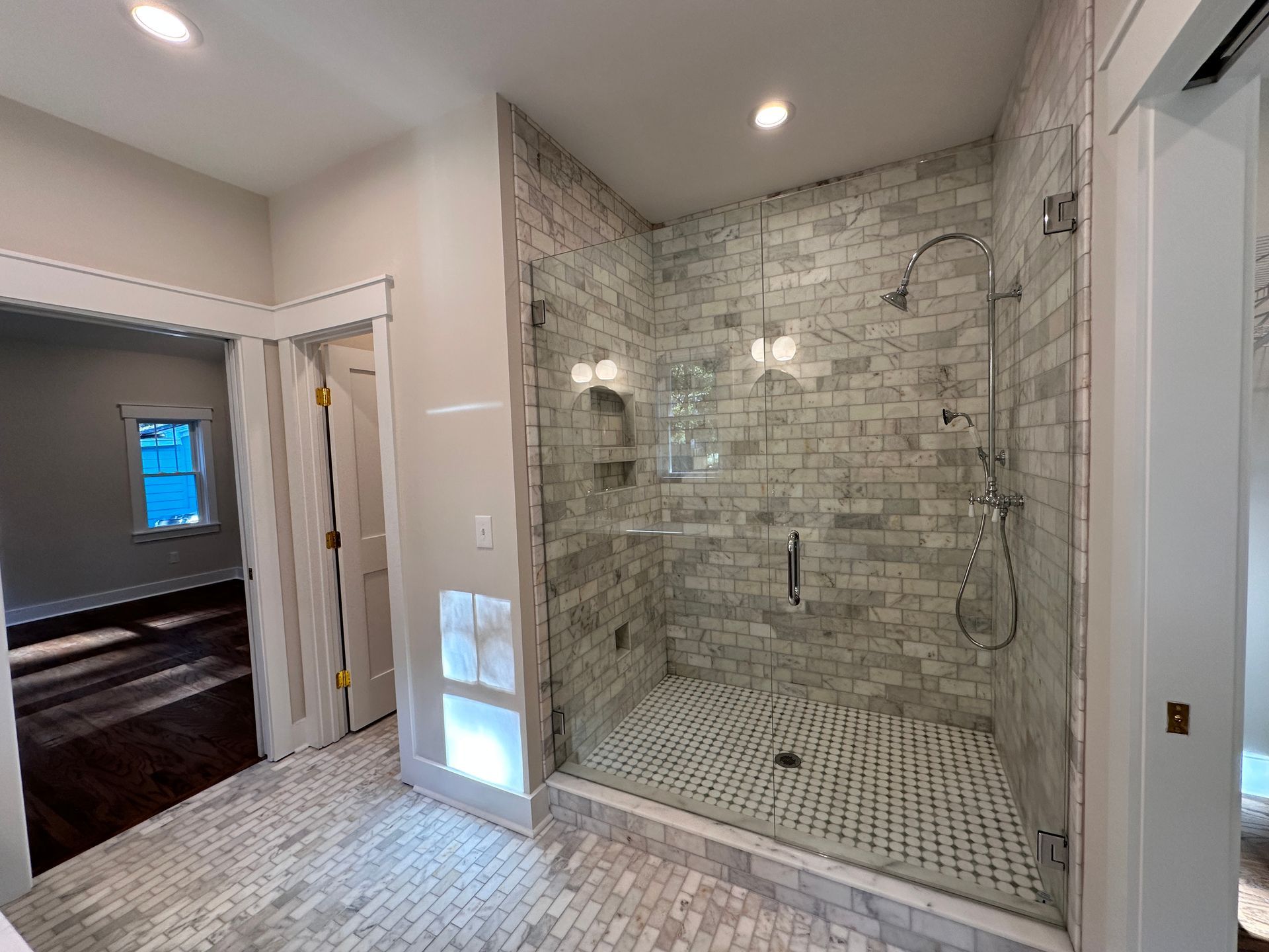 A bathroom with a walk in shower with a glass door.