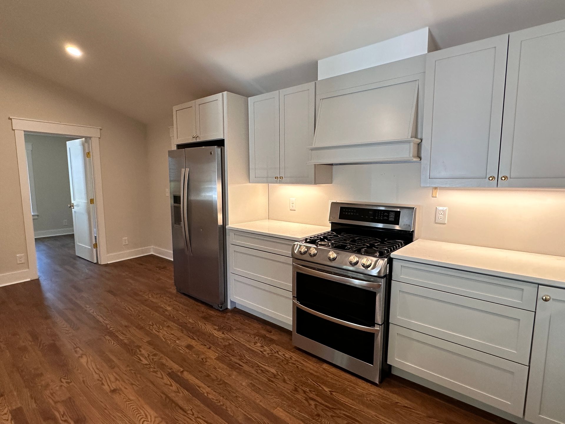 A kitchen with stainless steel appliances and white cabinets