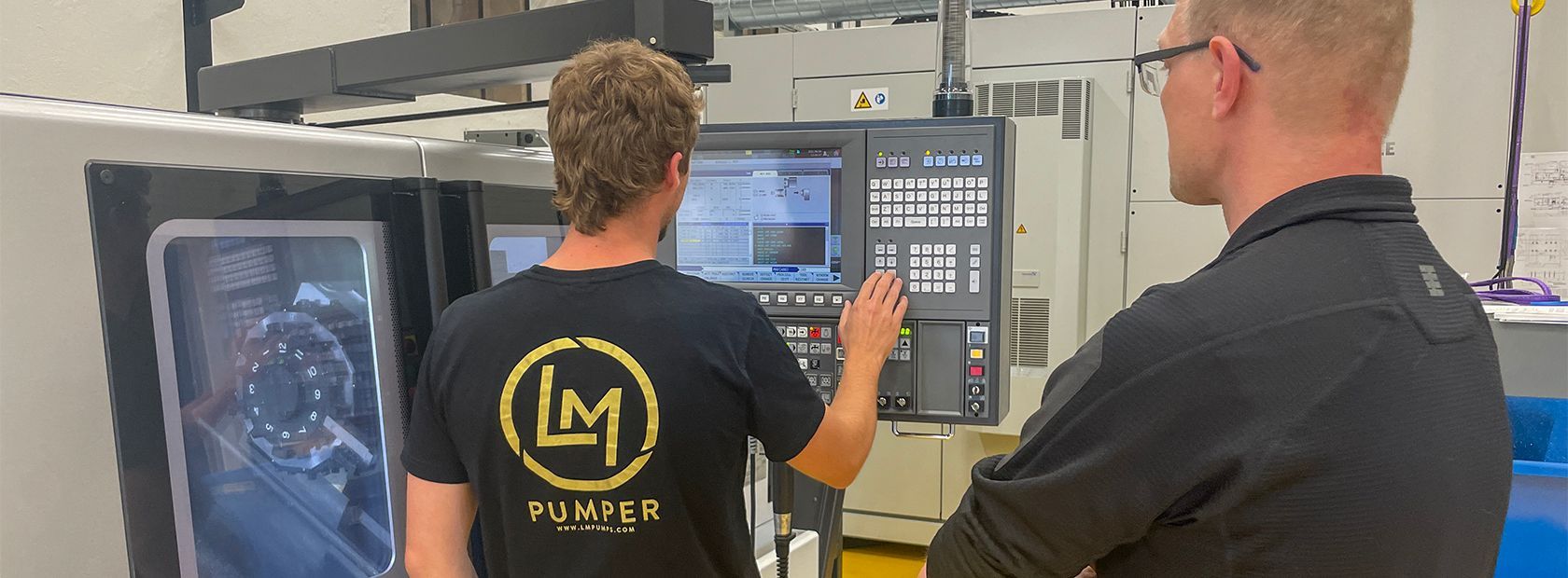 Men in front of an industrial machine, programming 