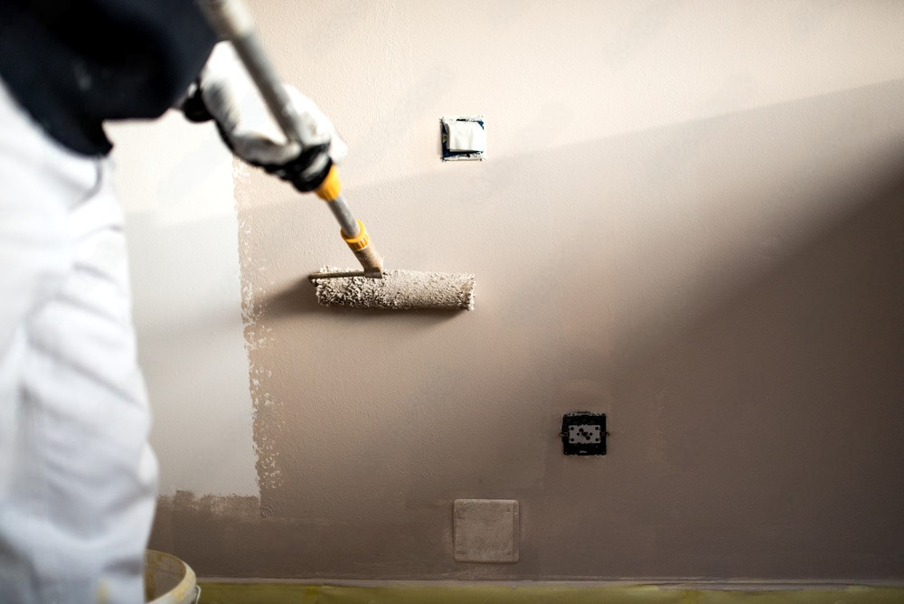 a person is using a paint roller to paint a wall