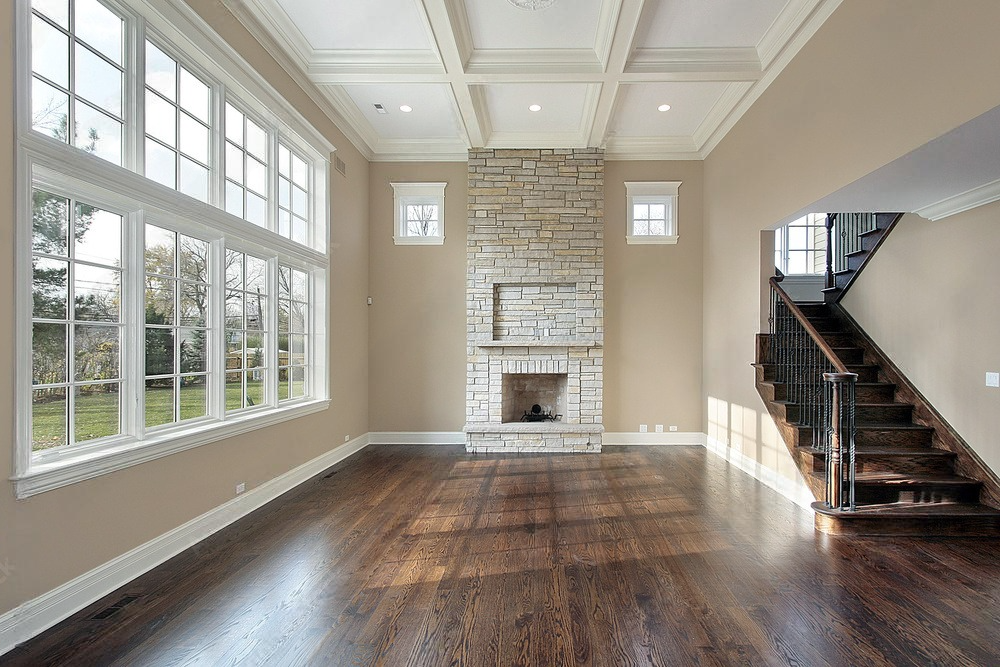 A cozy family room featuring a two-story fireplace as the focal point, set against the backdrop of warm hardwood floors.