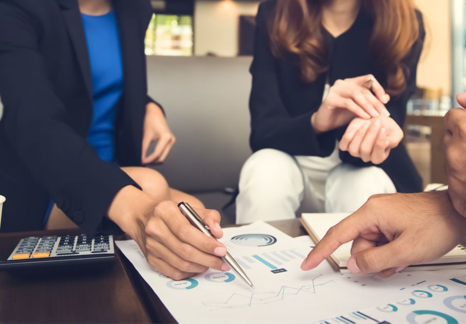 Business colleagues reviewing financial charts in an office setting.
