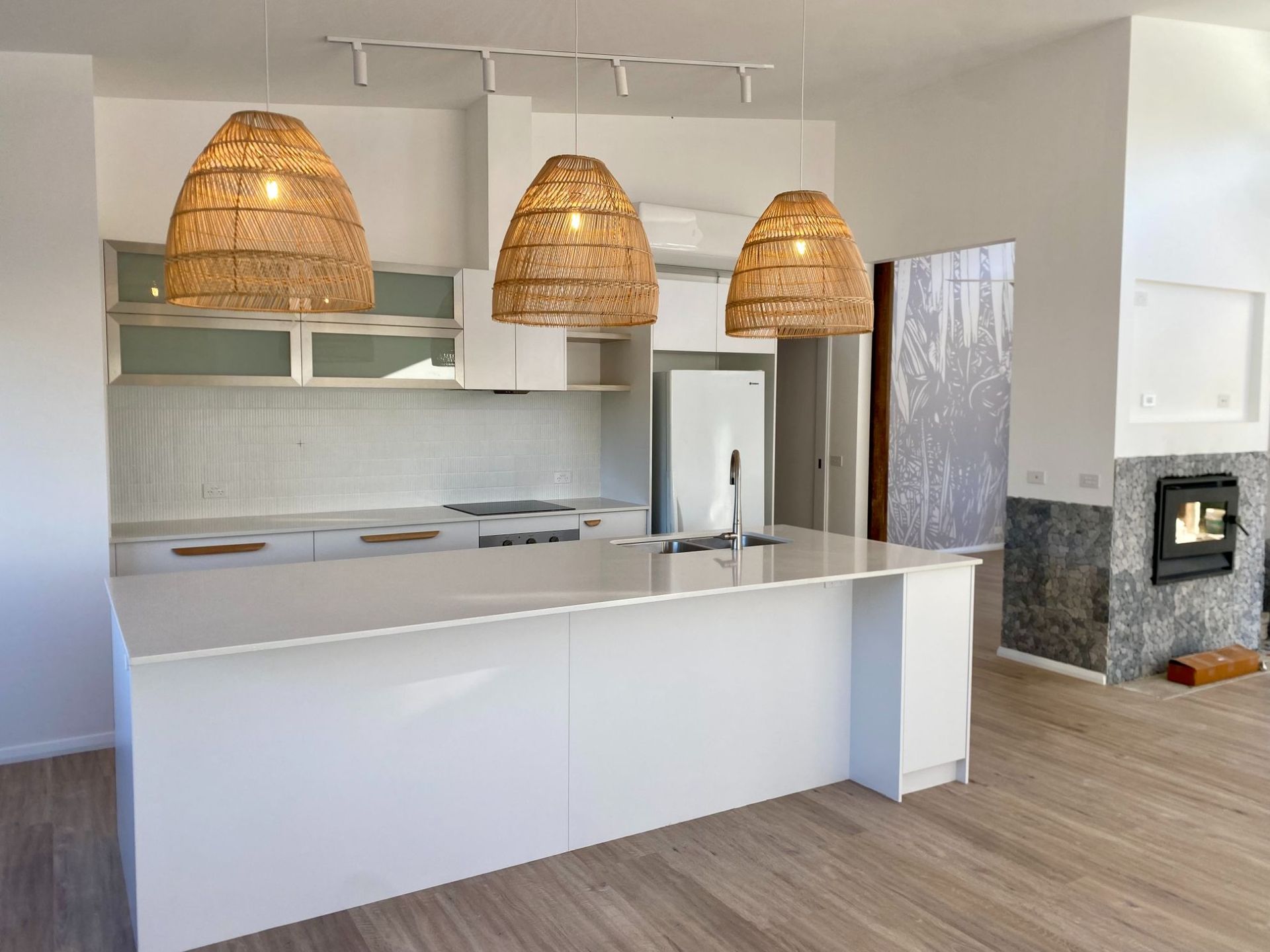 A Black House With Stairs Leading Up To It Is Sitting On Top Of A Grassy Hill — Nambucca Construction In Nambucca Heads, NSW