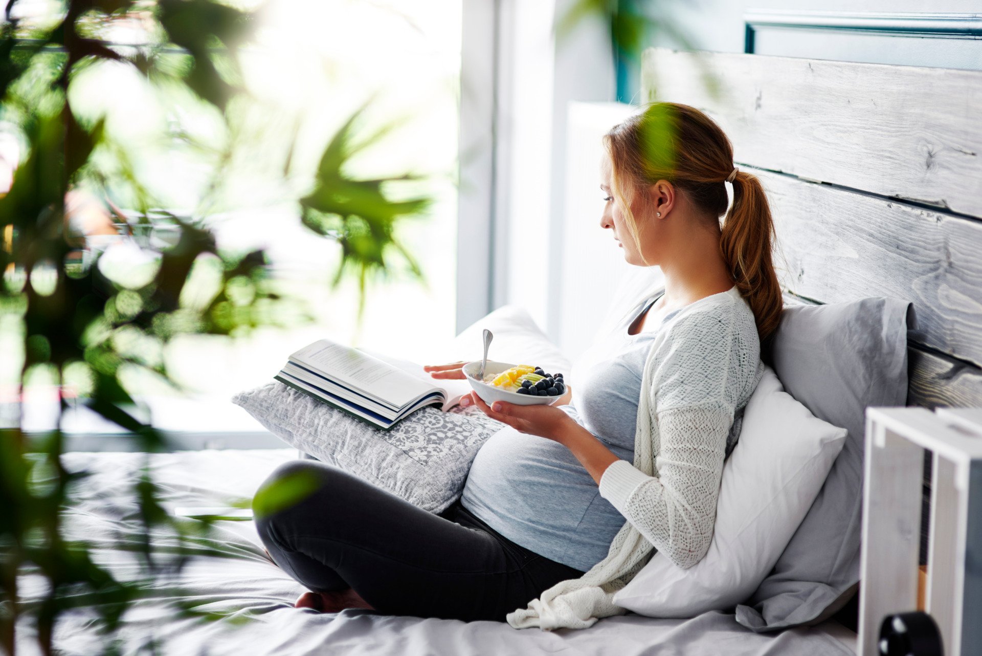 a pregnant woman reading a book