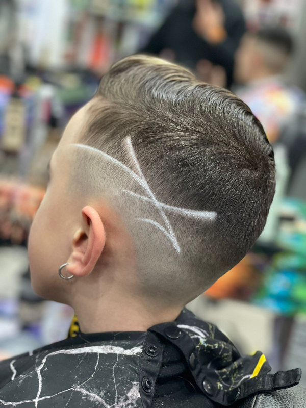 Un ragazzino si fa tagliare i capelli dal barbiere.