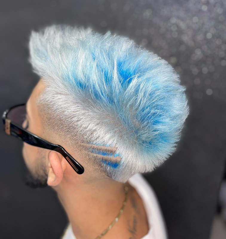 Un uomo con i capelli blu e gli occhiali da sole indossa un'acconciatura mohawk.