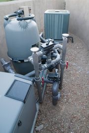 Swimming pool equipment is sitting next to a pool heater.