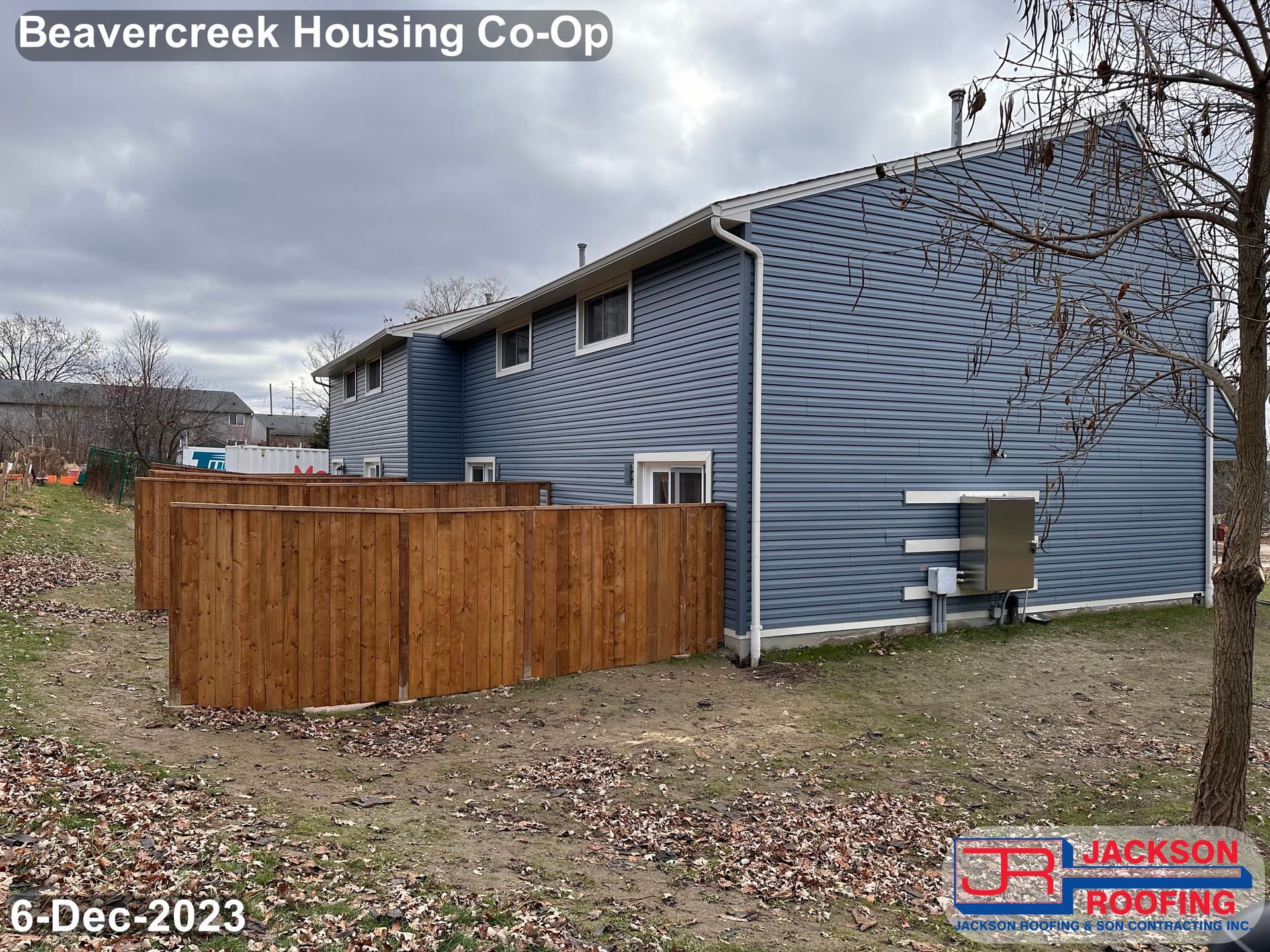 A blue house with a wooden fence in front of it