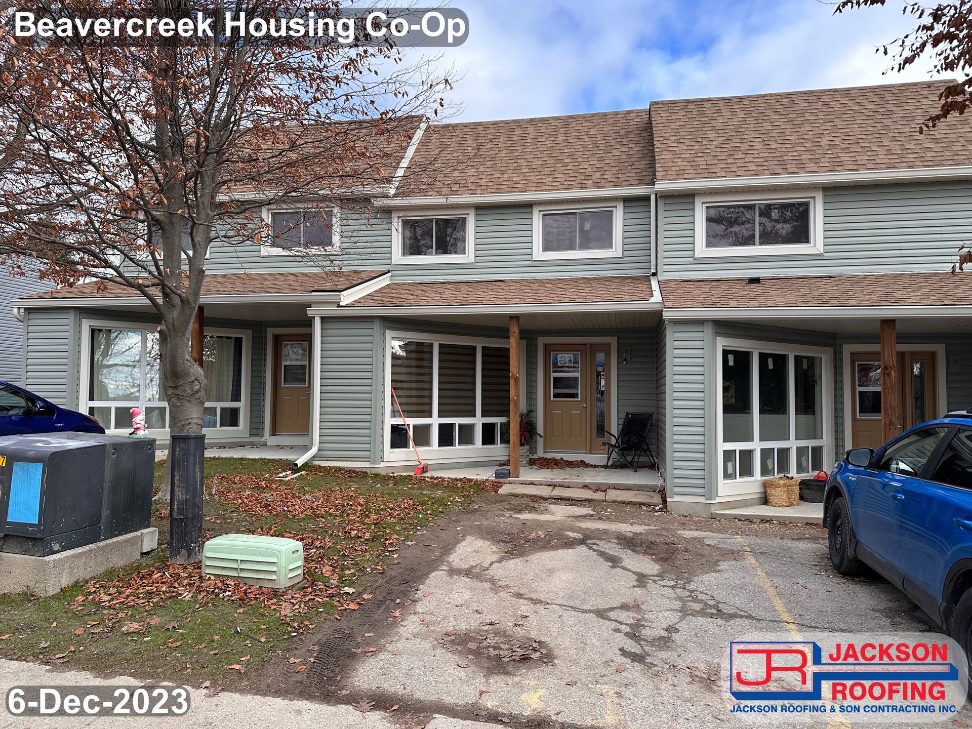 A blue car is parked in front of a beavercreek housing co-op.