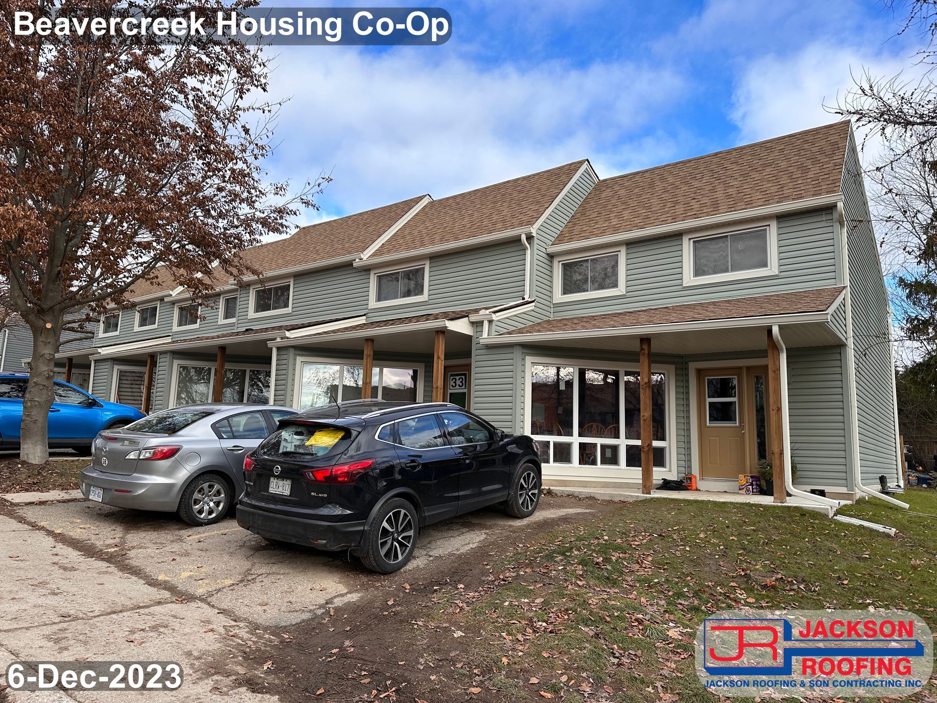 A row of houses with cars parked in front of them.