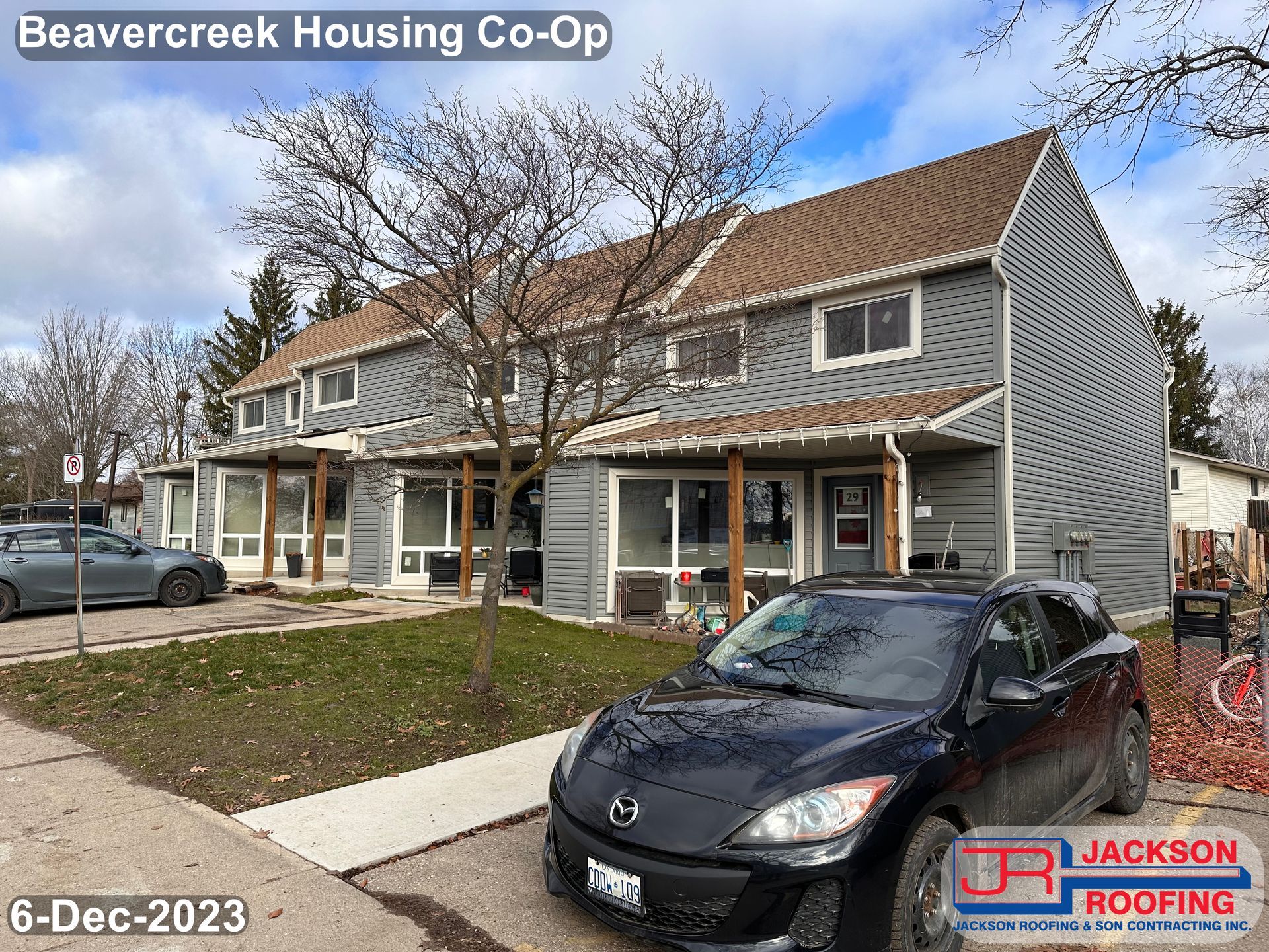 A black car is parked in front of a house.