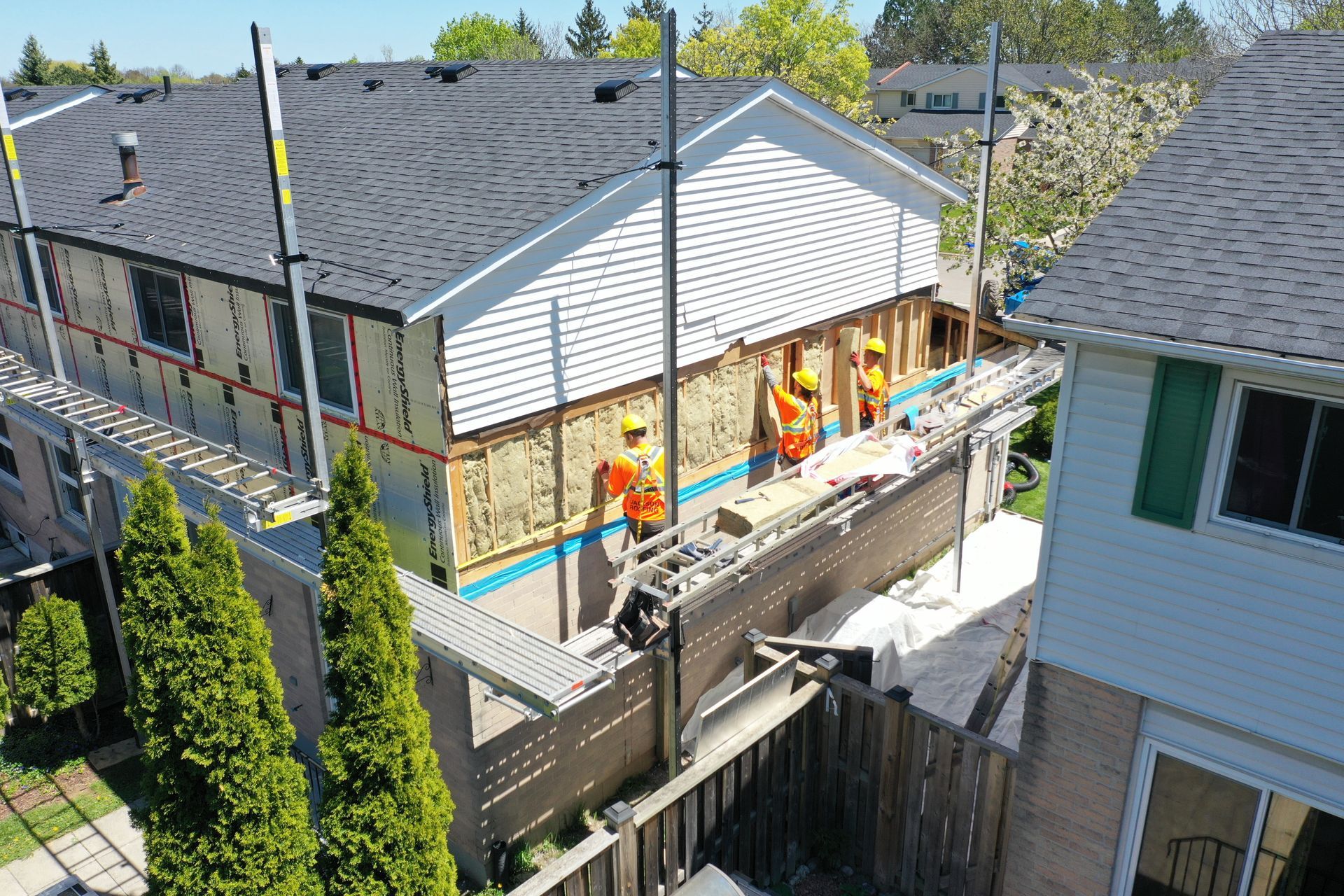 A group of construction workers are working on a house.