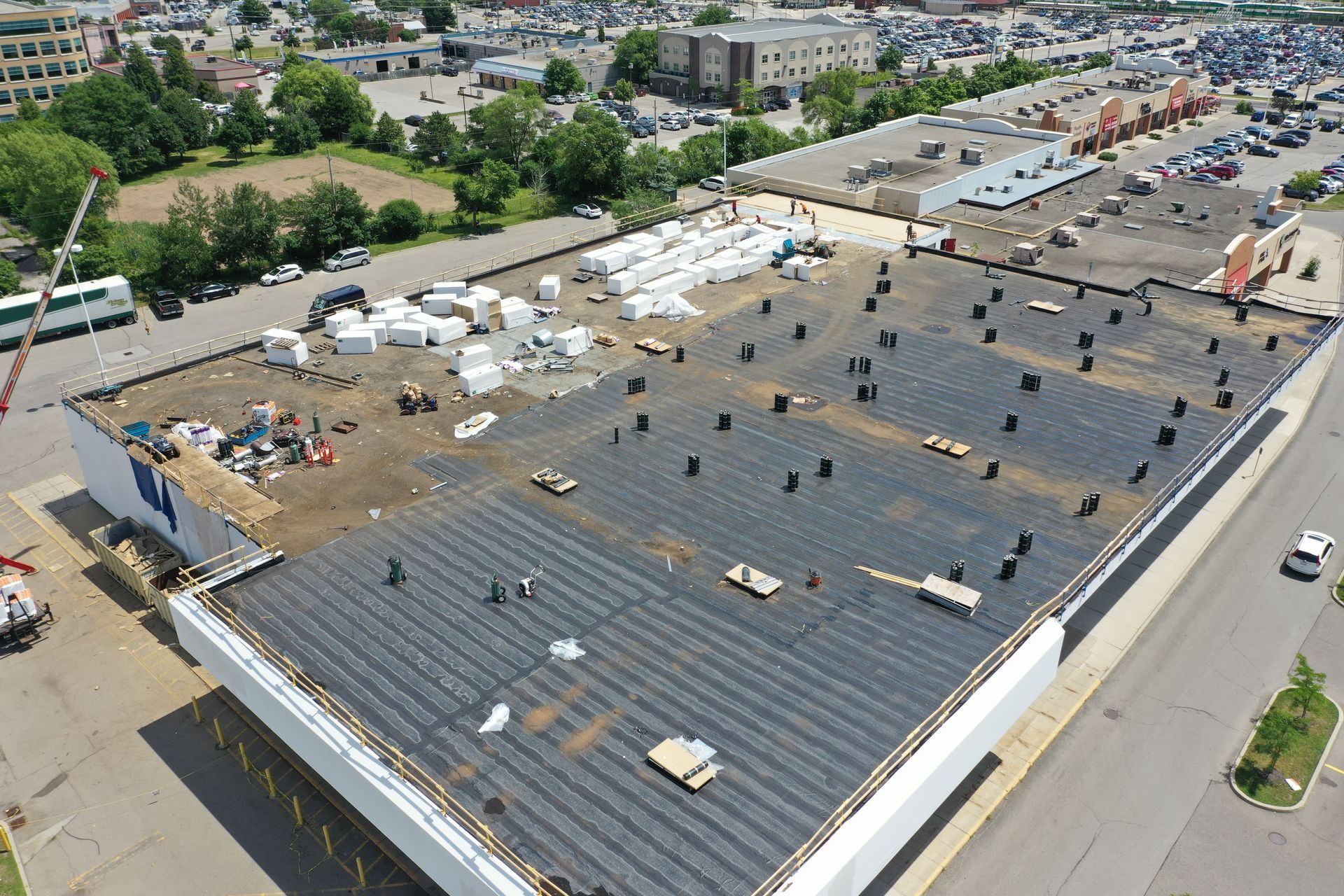 An aerial view of a large building with a roof that is being repaired.