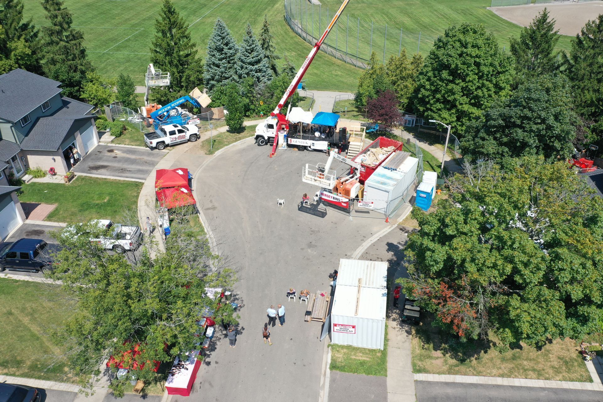 An aerial view of a residential neighborhood with a crane in the middle of the street.