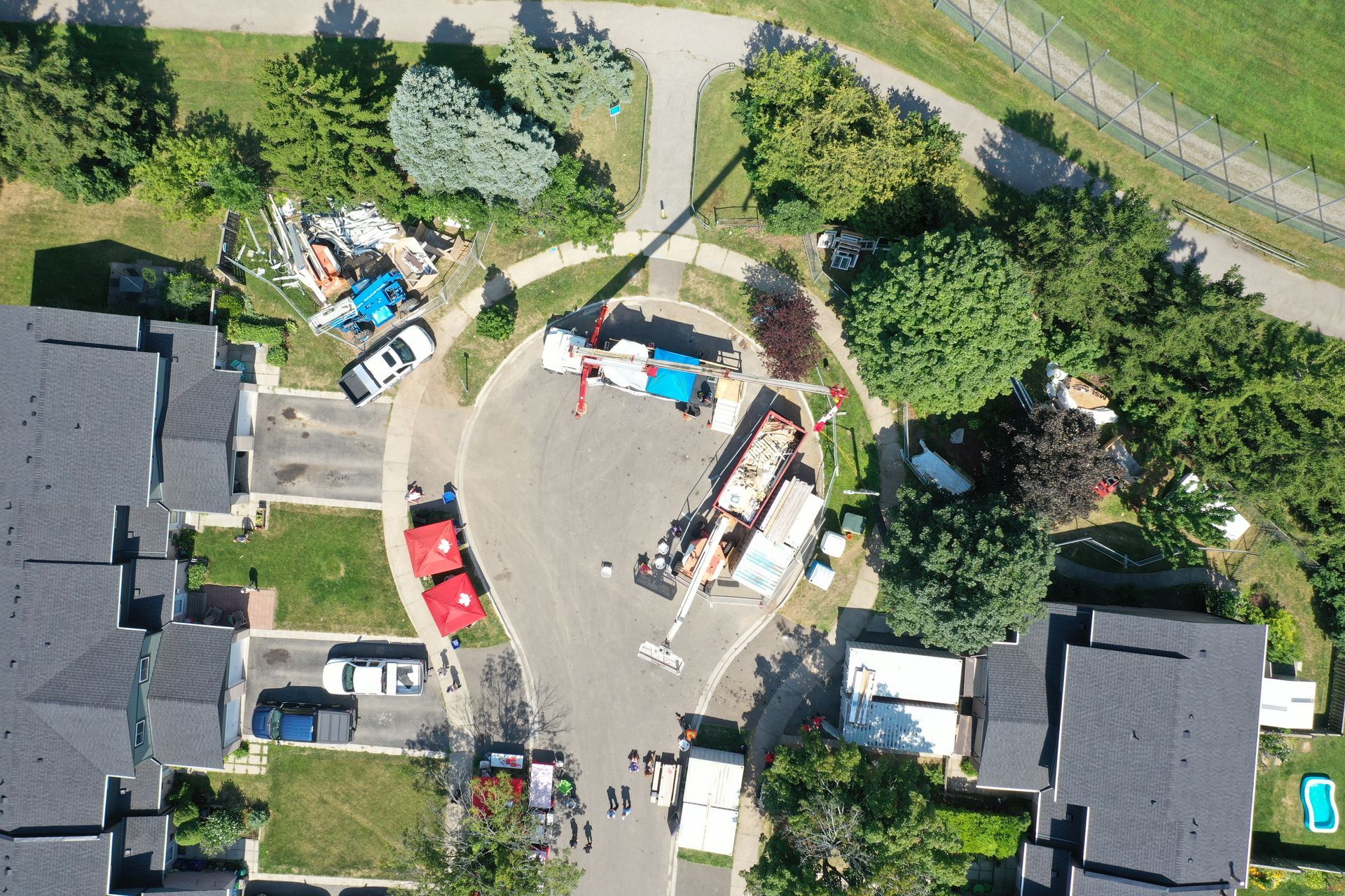 An aerial view of a residential area with cars parked on the side of the road
