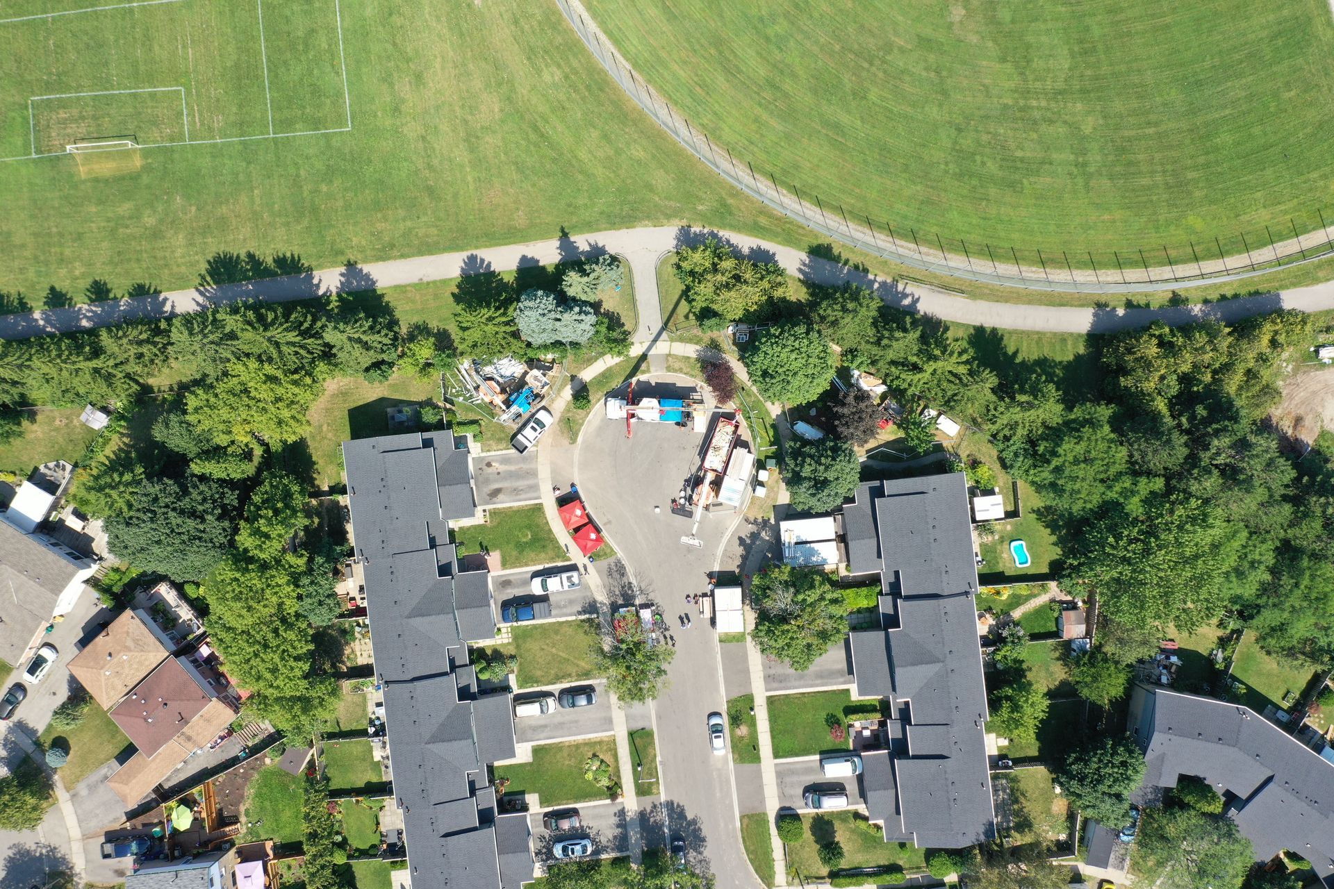 An aerial view of a residential area with a soccer field in the background