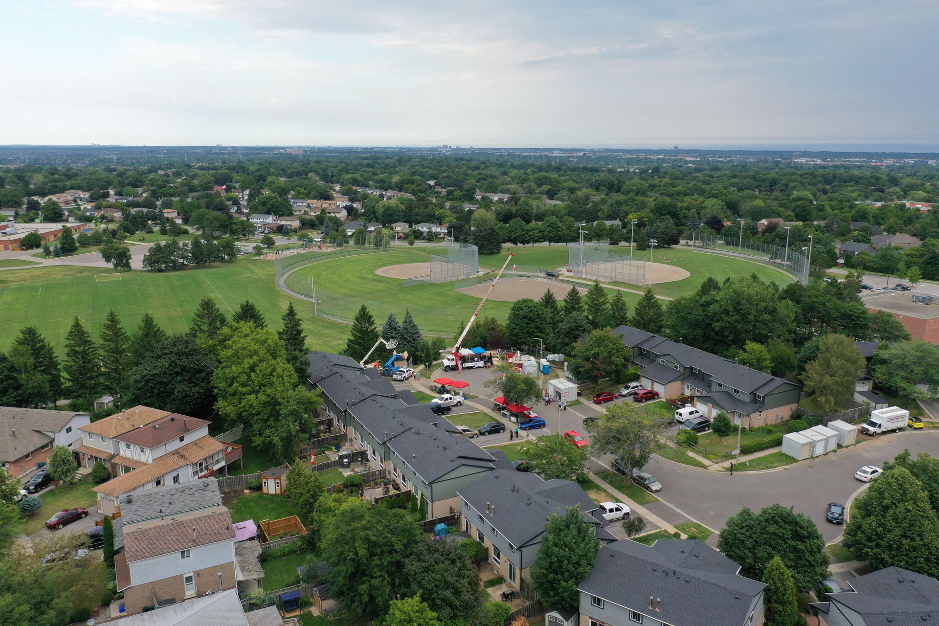 An aerial view of a residential area with a baseball field in the background.