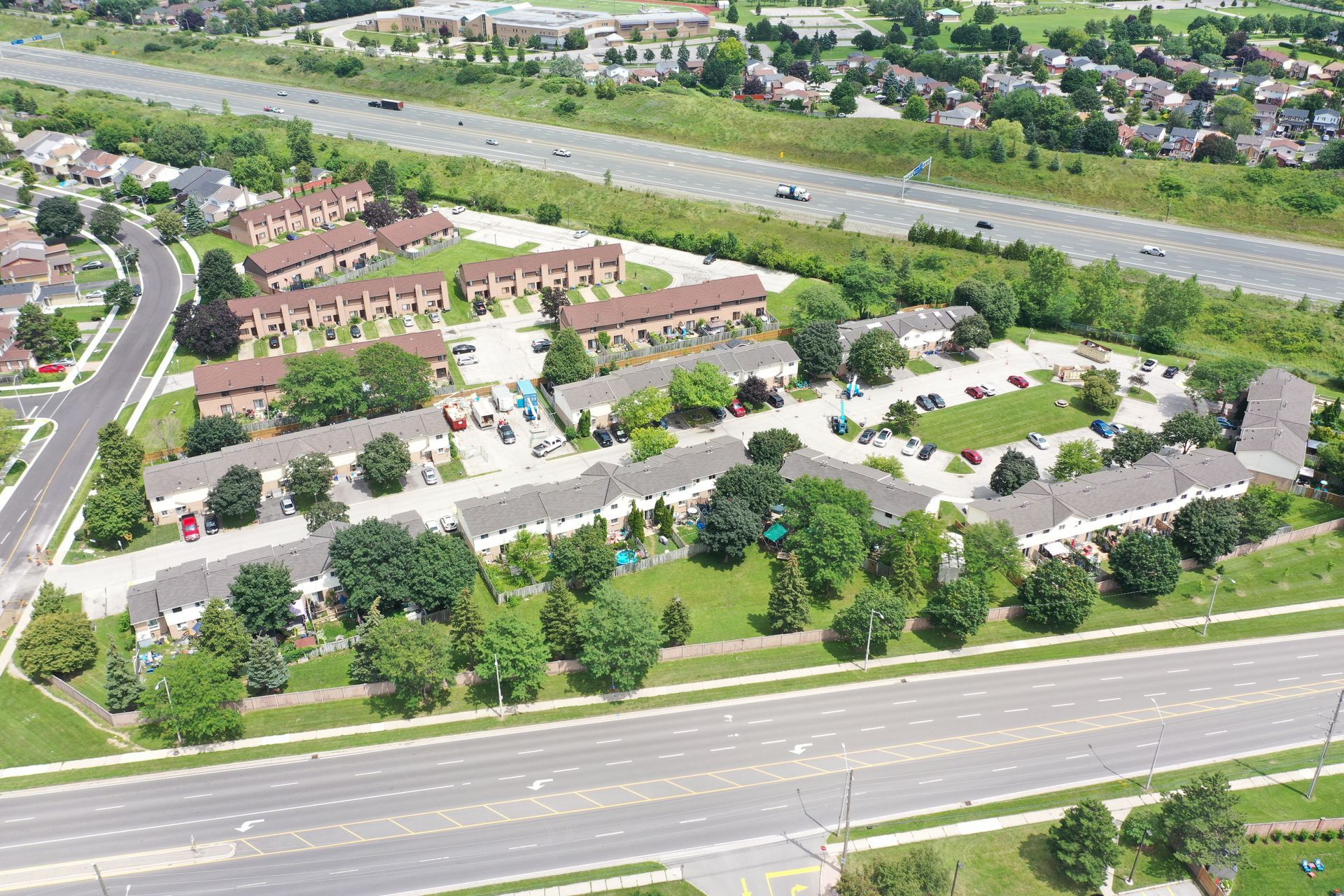 An aerial view of a residential area with a highway in the background.