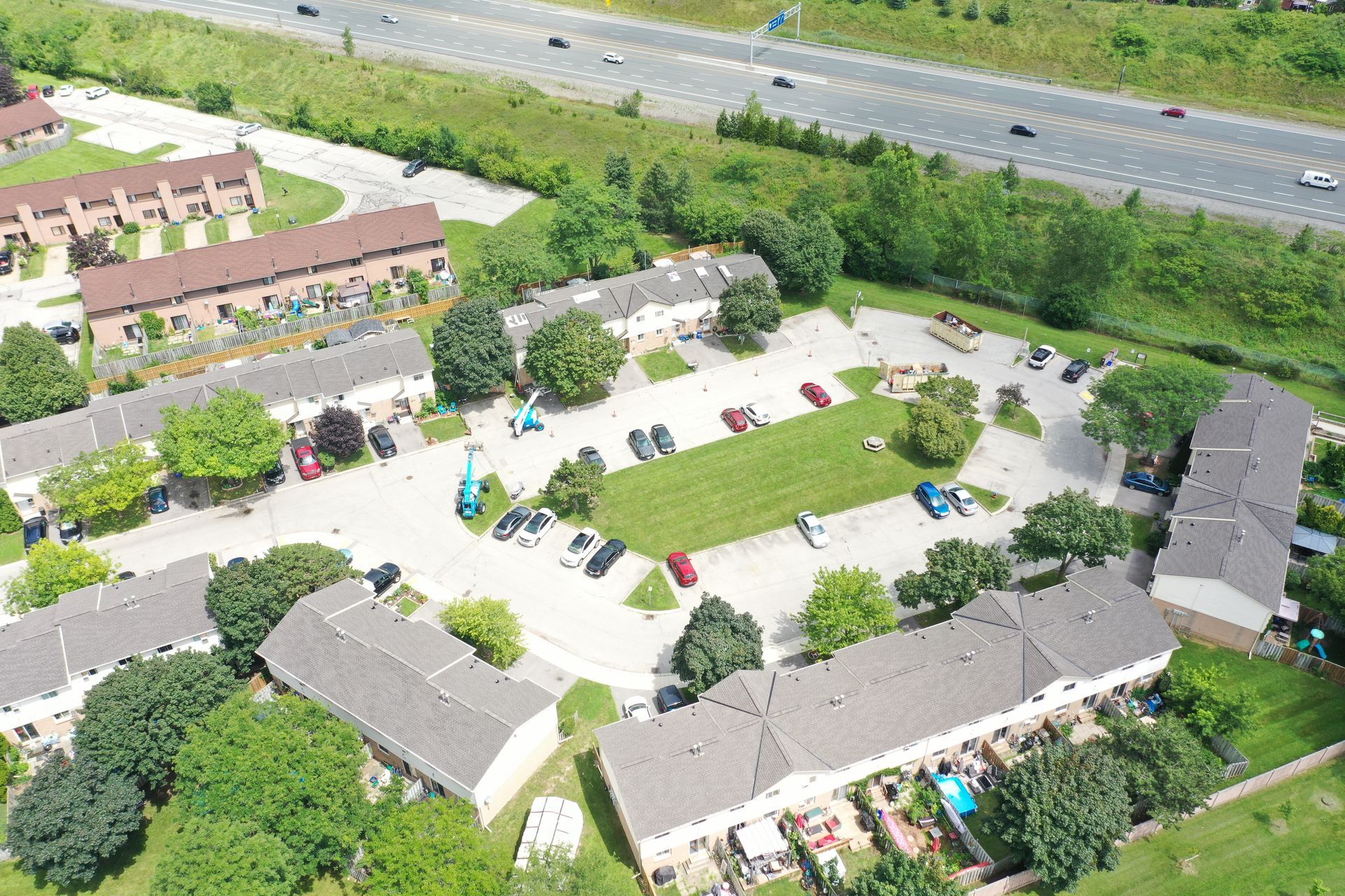 An aerial view of a residential area with a highway in the background