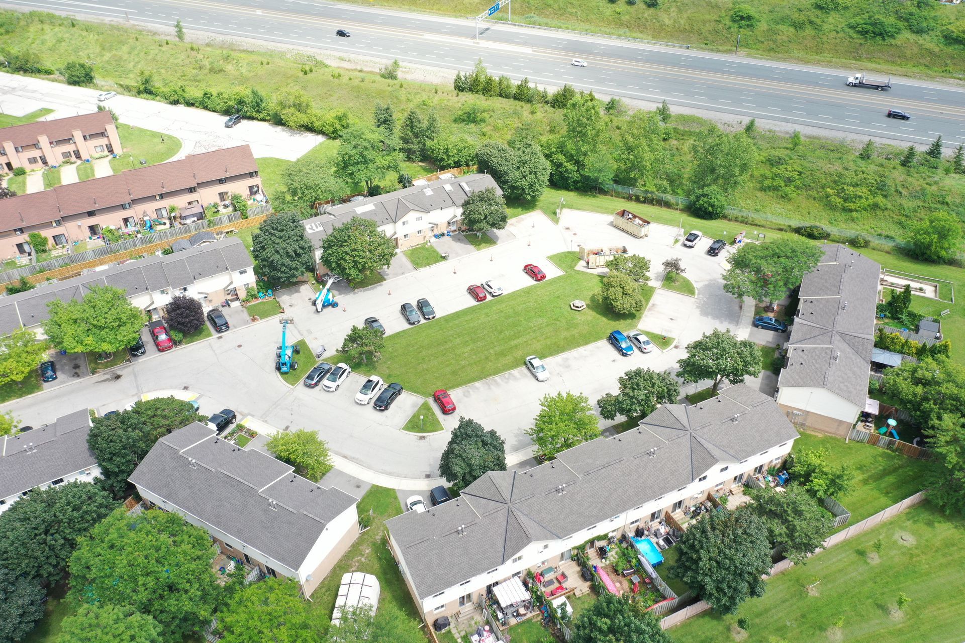 An aerial view of a residential area with a highway in the background