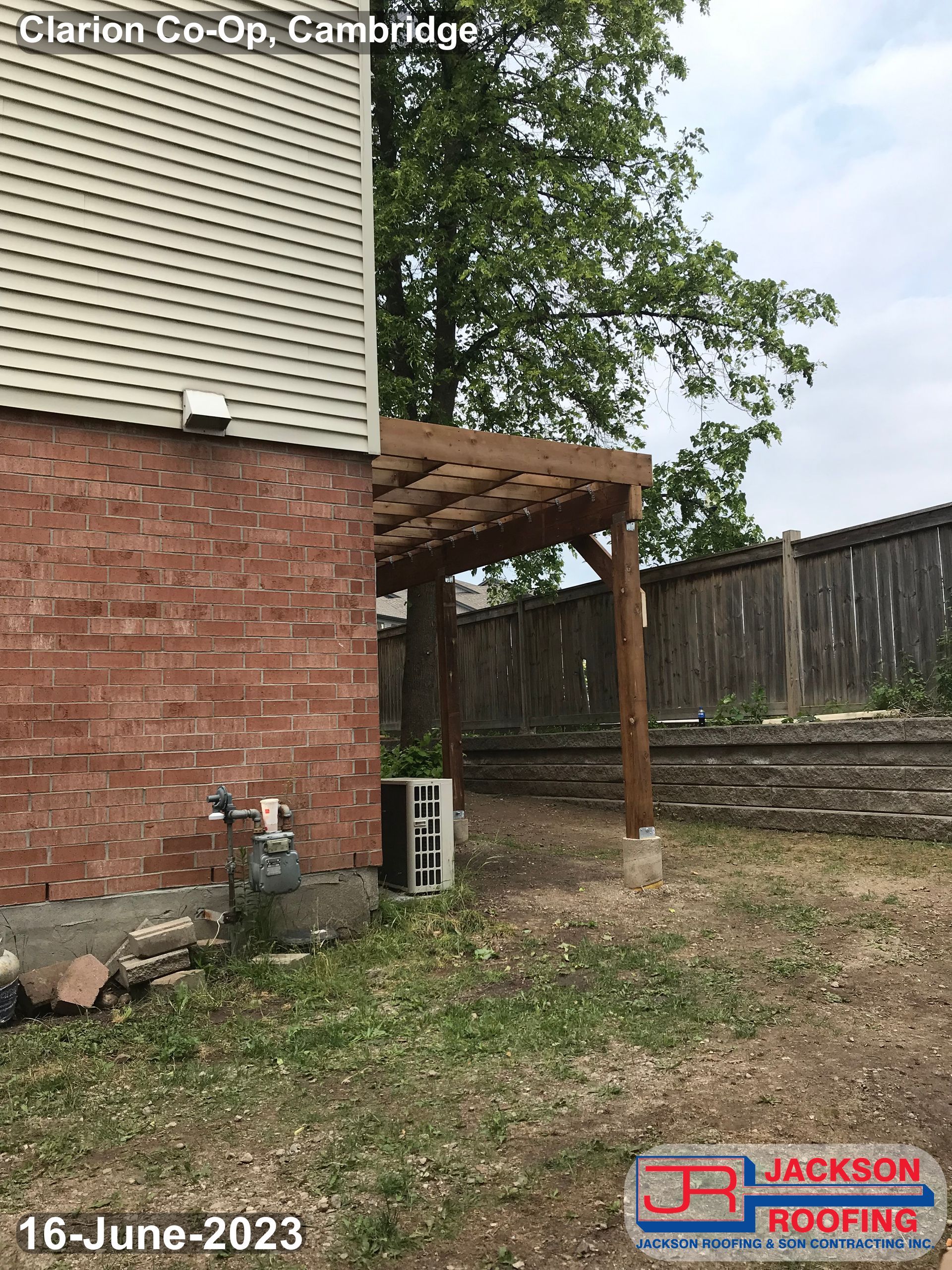 There is a pergola in the backyard of a house.