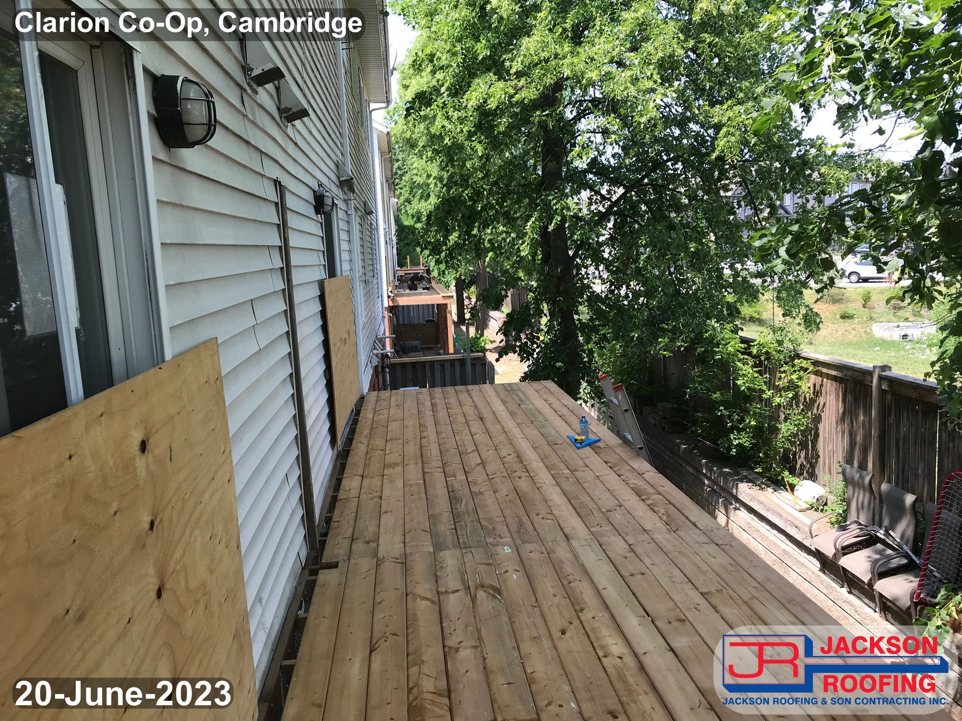 A wooden deck is being built on the side of a house.