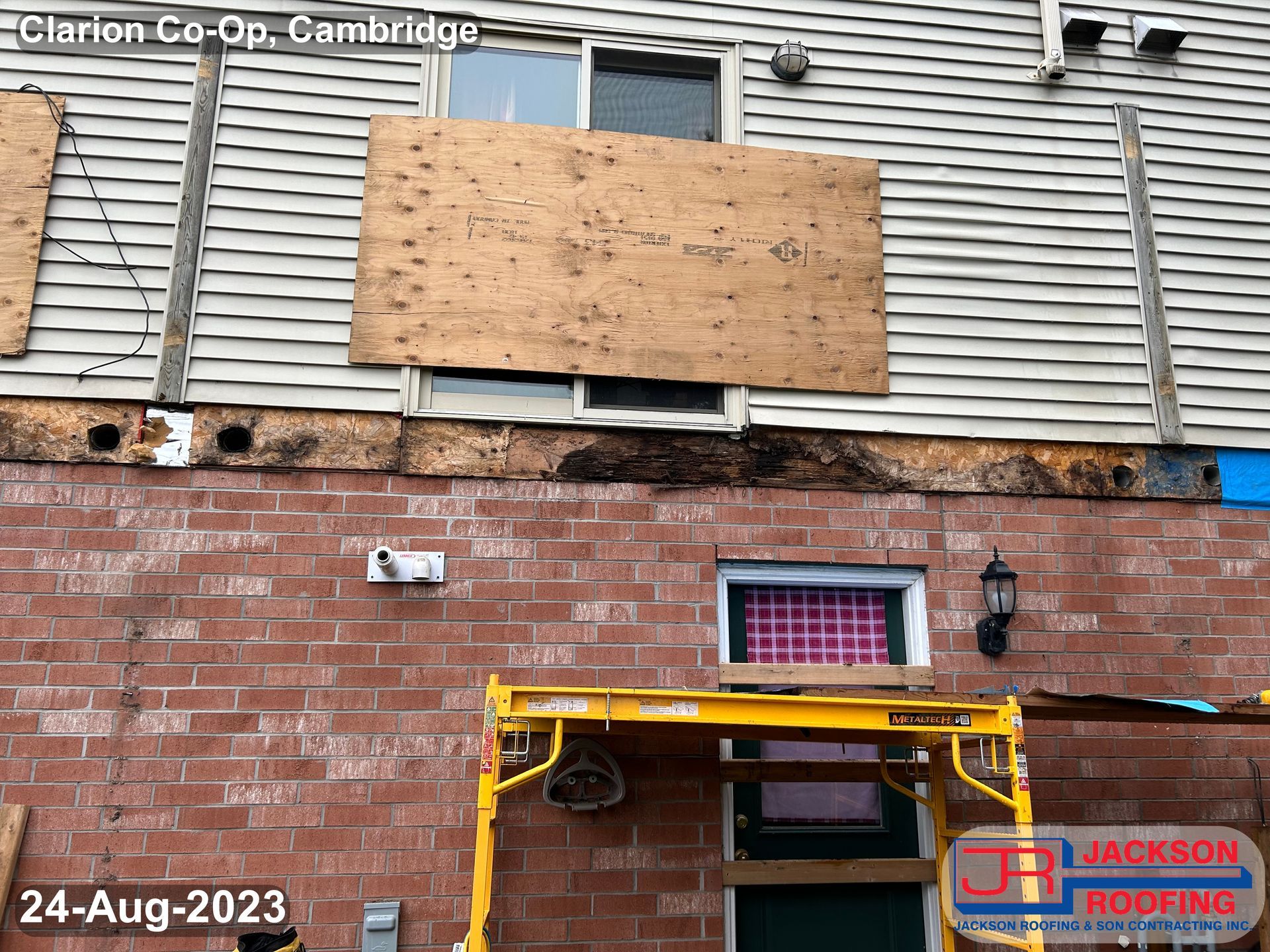 A brick building with a yellow scaffolding in front of it