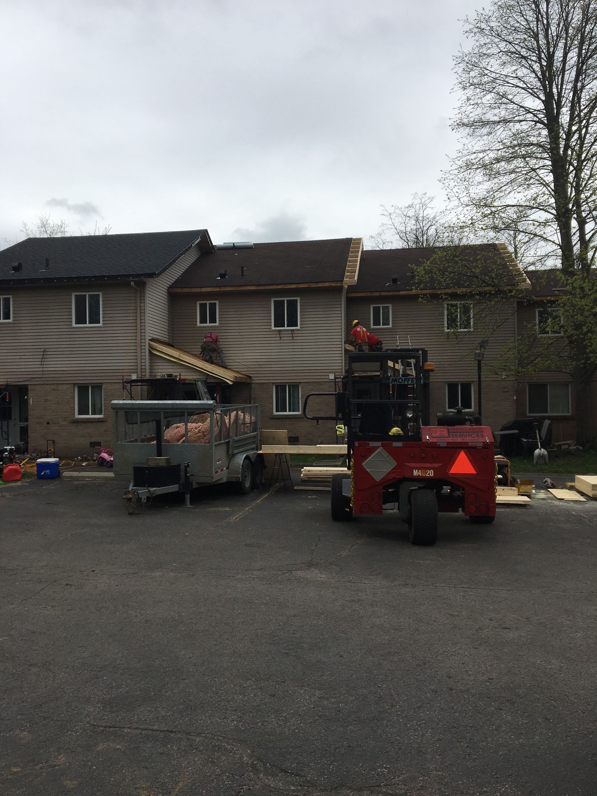 A red forklift is parked in front of a house