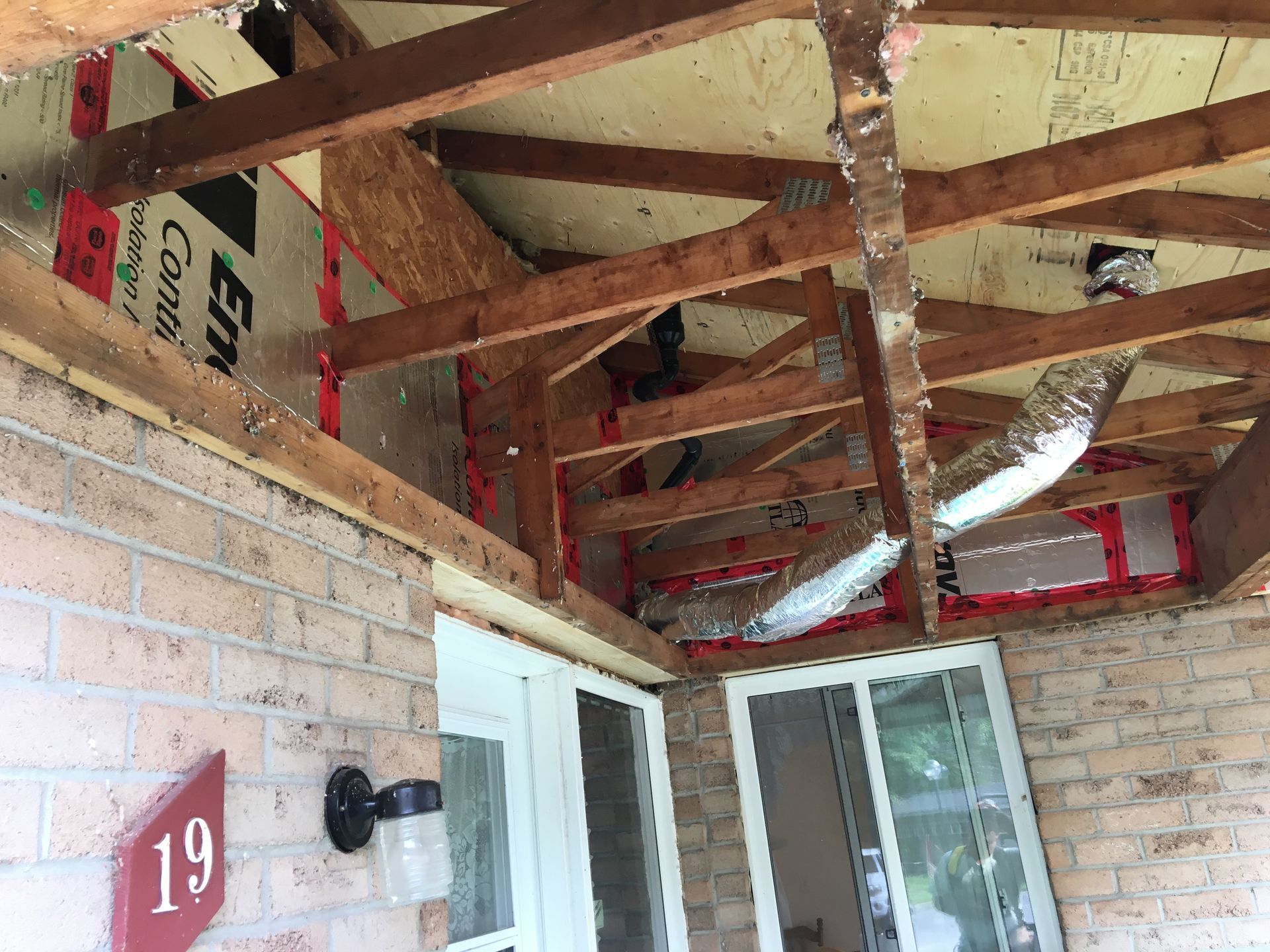 The ceiling of a porch is being remodeled.