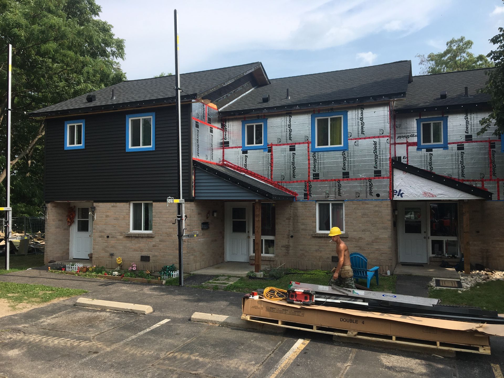 A man is standing in front of a building that is being remodeled.