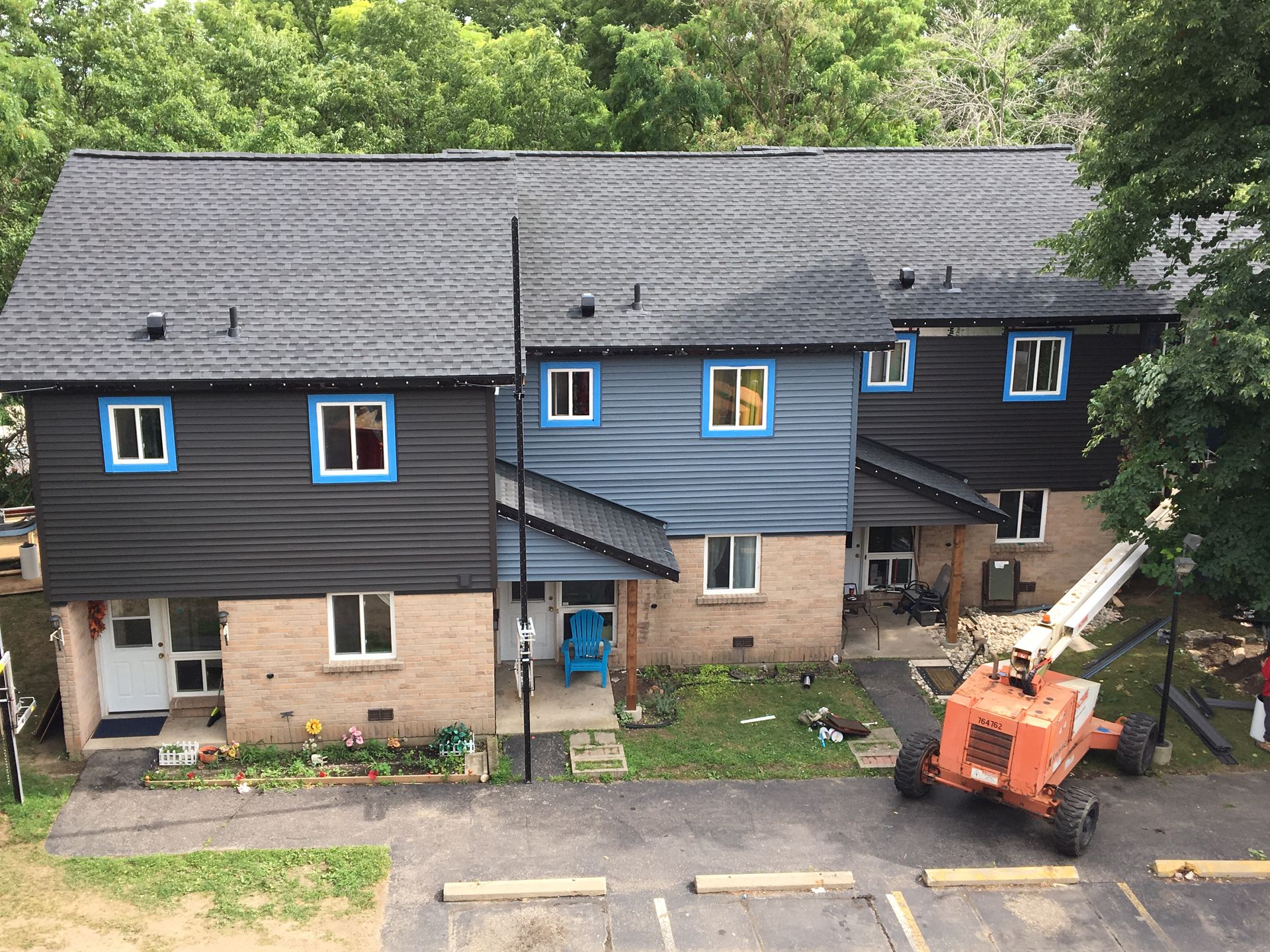An aerial view of a row of houses with blue windows