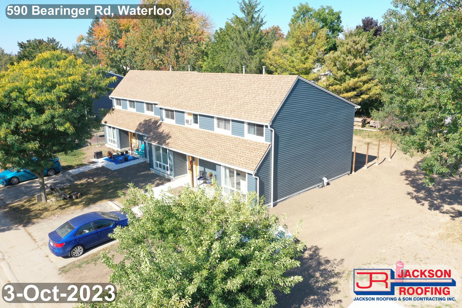 An aerial view of a house with a blue car parked in front of it.