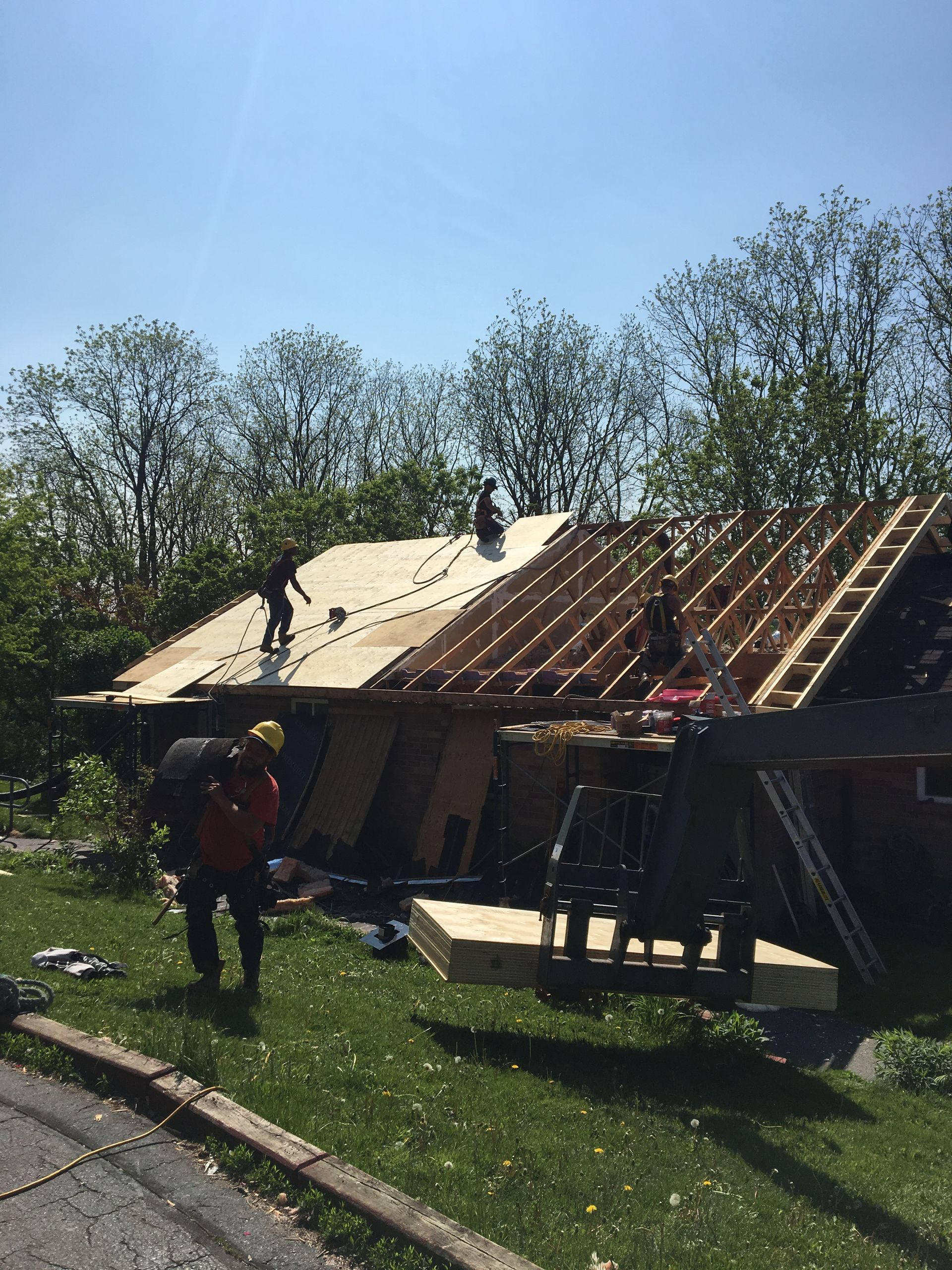 A group of people are working on the roof of a house.
