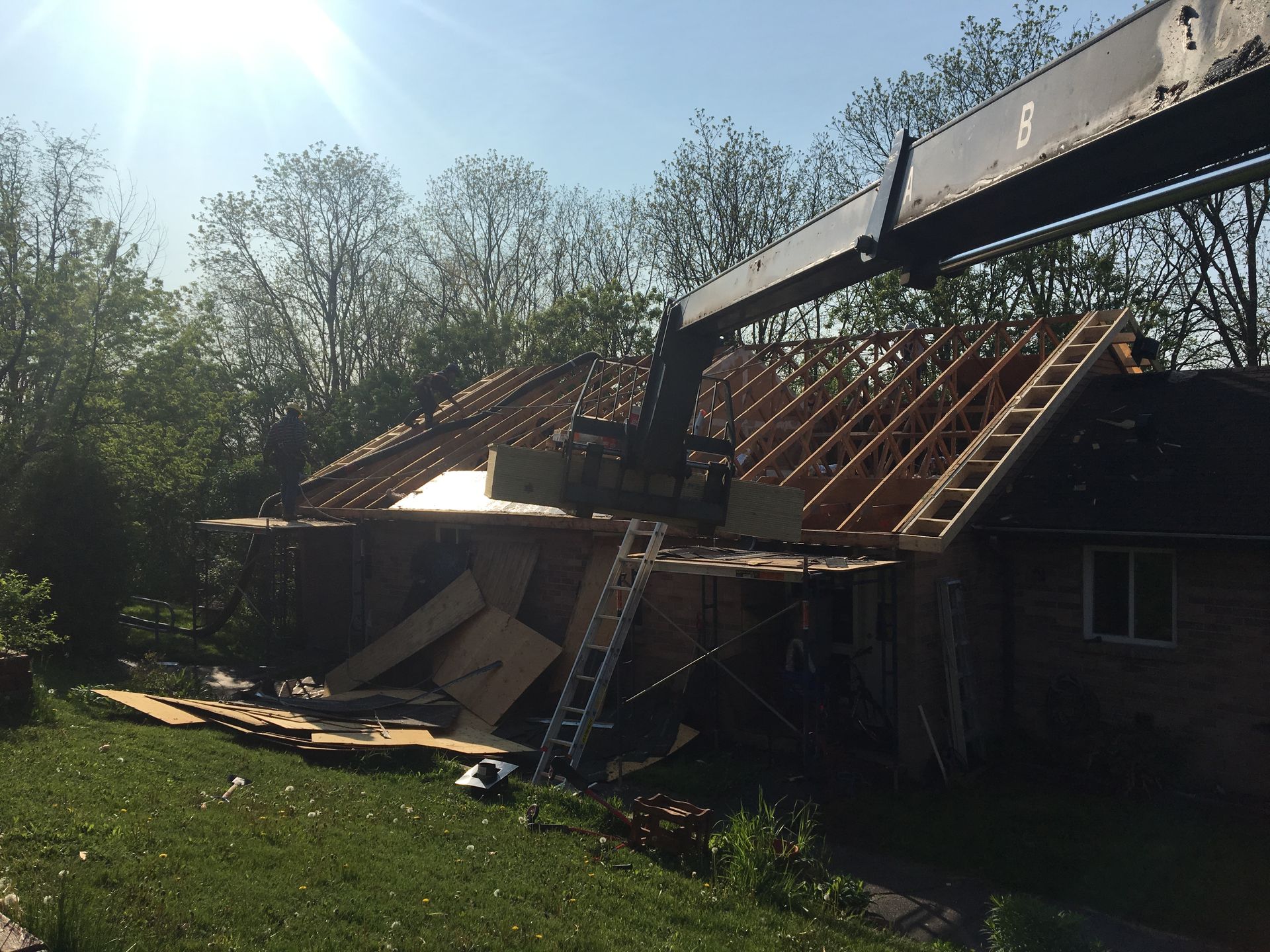 A crane is lifting the roof of a house
