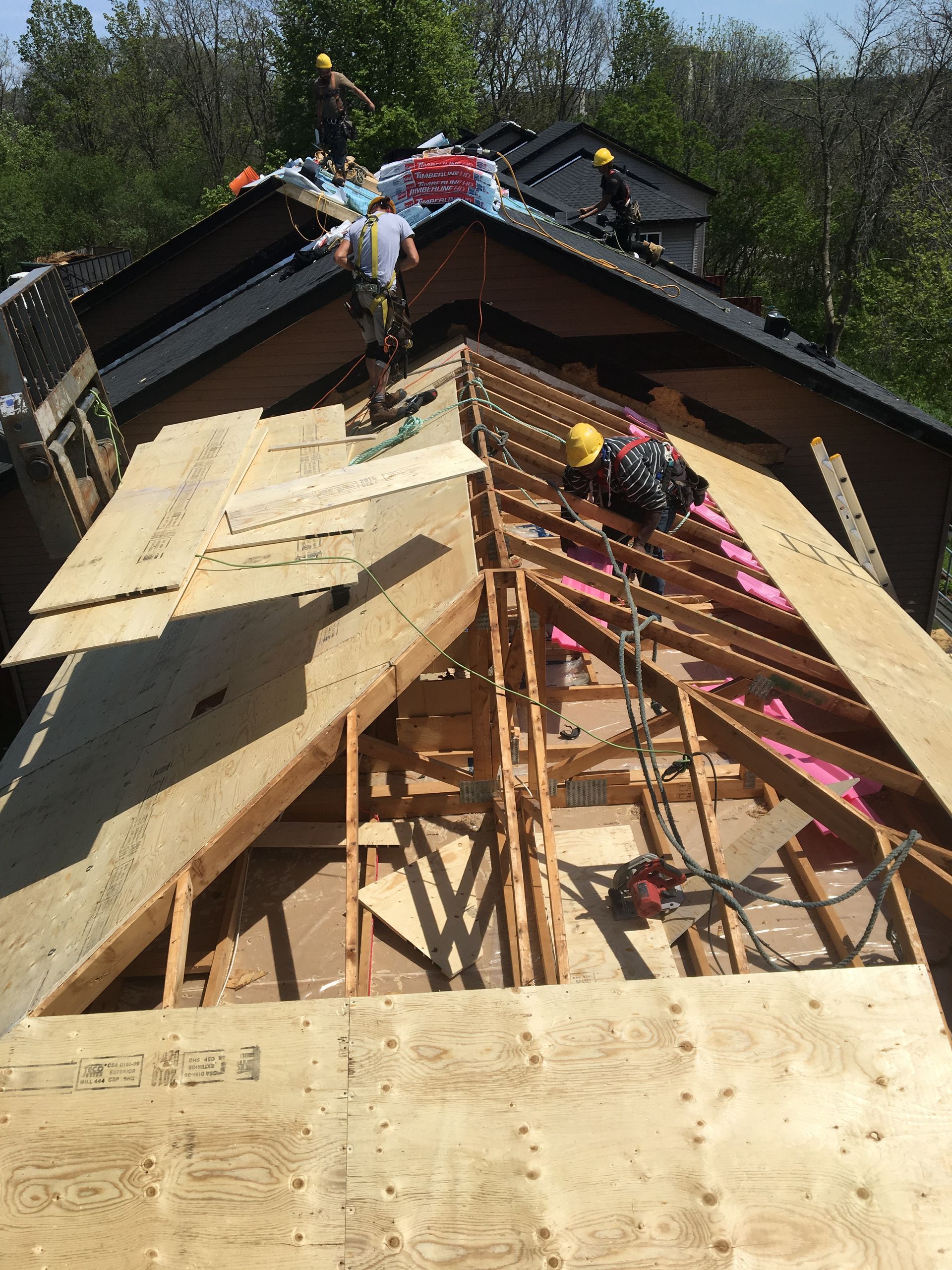 A group of people are working on the roof of a house.