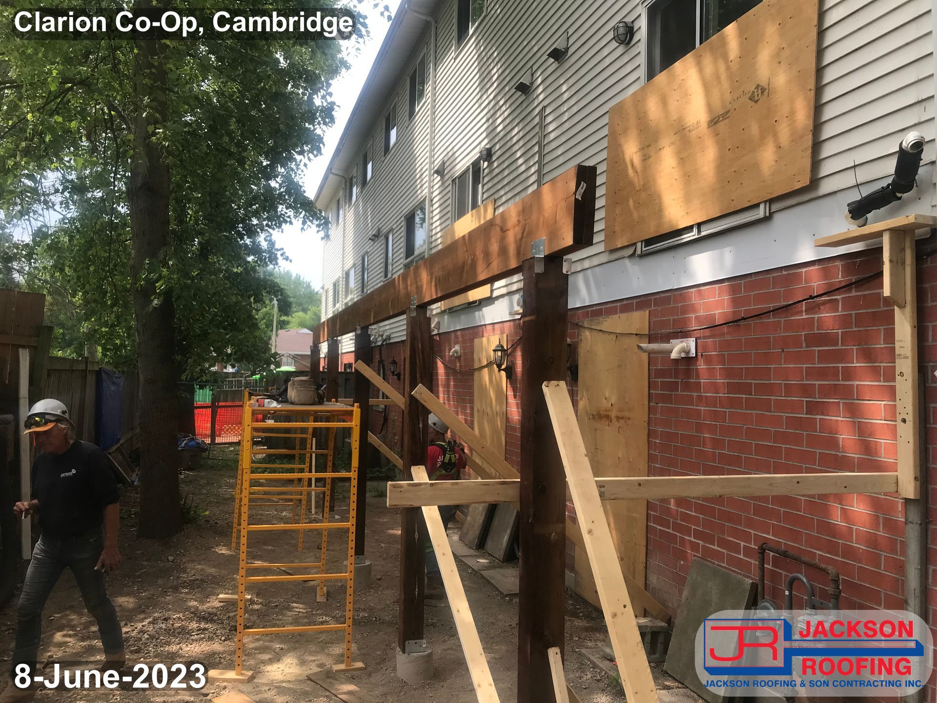 A man is standing in front of a building that is being remodeled.