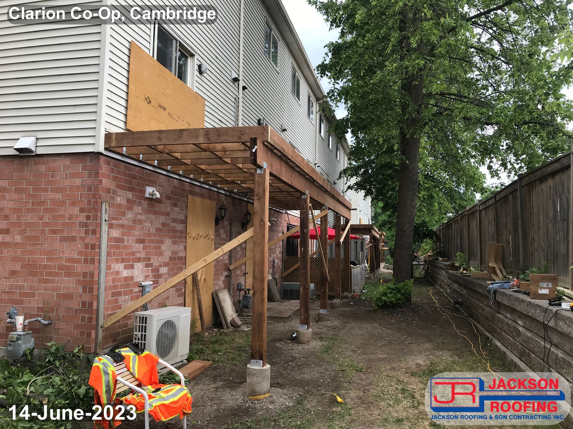 A wooden deck is being built on the side of a house.
